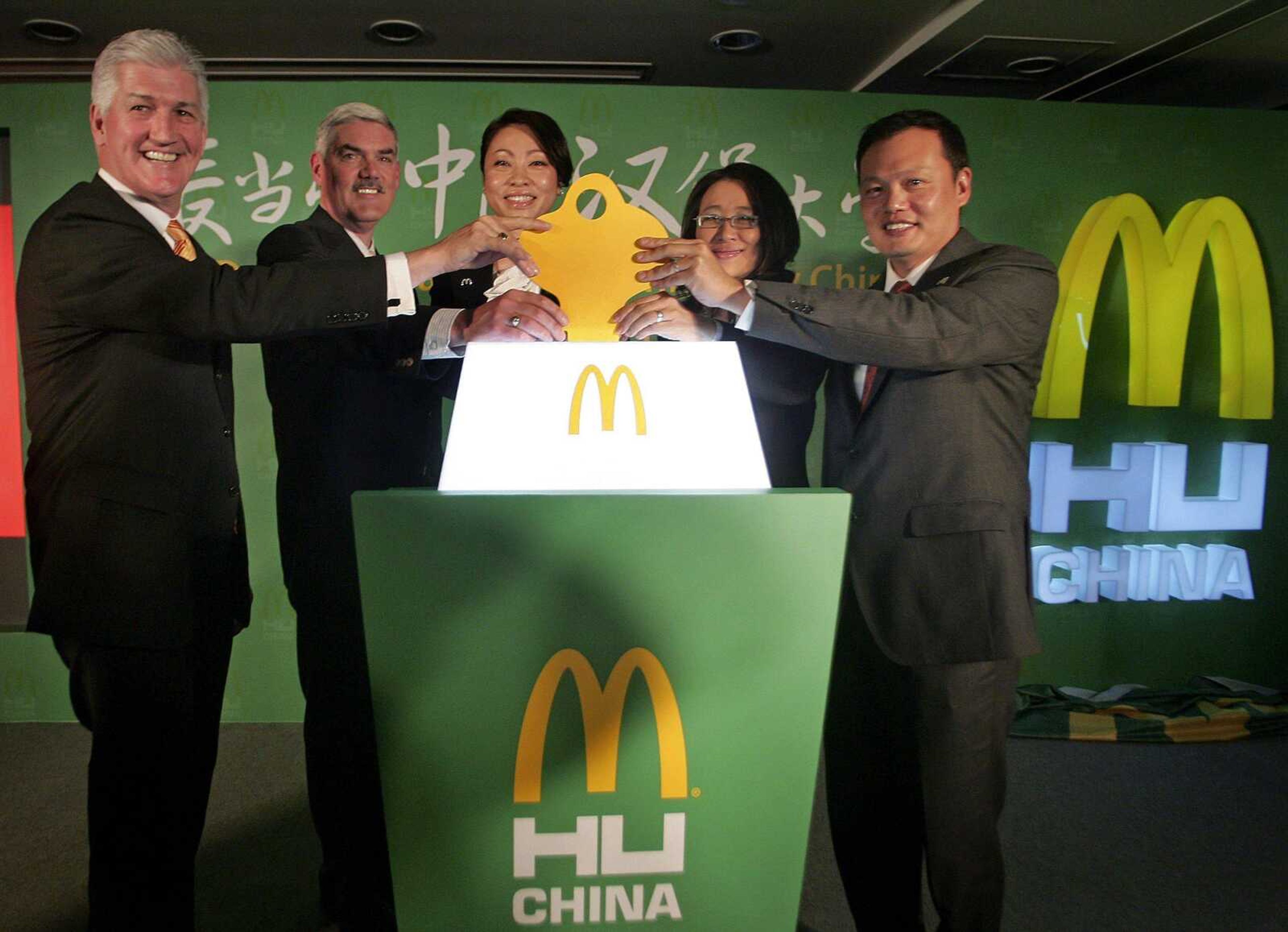 Tim Fenton, left, McDonald's president for Asia, Pacific, Middle East and Africa, launches the McDonald's Hamburger University with school officers from left, Chris Lyons, Susanna Li, Lynn Tan and Kenneth Chan in Shanghai, China, on Tuesday. McDonald's inaugurated its first Hamburger University in China on Tuesday to train new generations of managers as foreign companies step up efforts to develop and keep Chinese talent. (Associated Press)