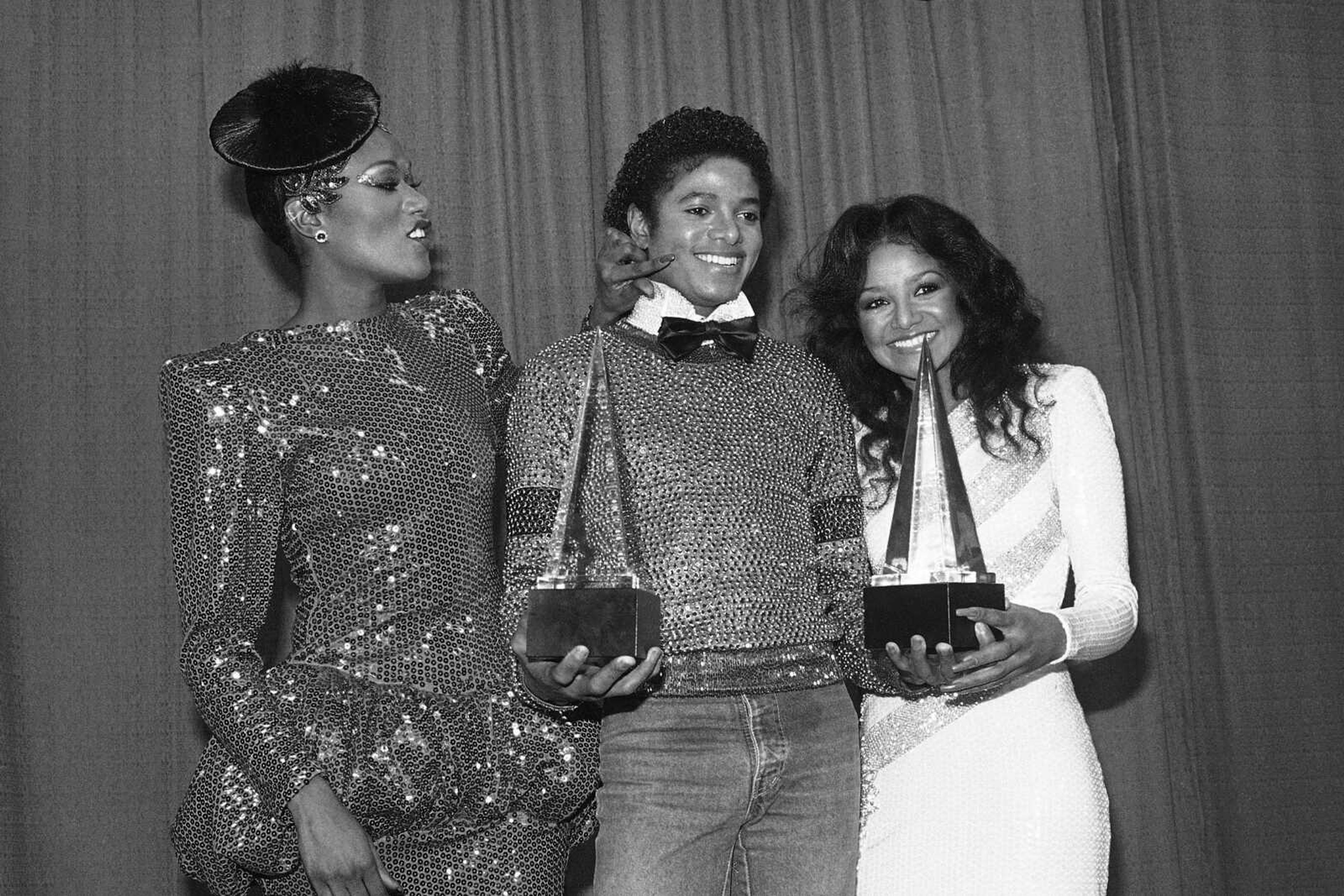 Singer Bonnie Pointer, left, touches singer Michael Jackson, center, on the cheek as Jackson's sister Latoya, right, smiles during the American Music Awards on Jan. 31, 1981, in Los Angeles. (Associated Press file)