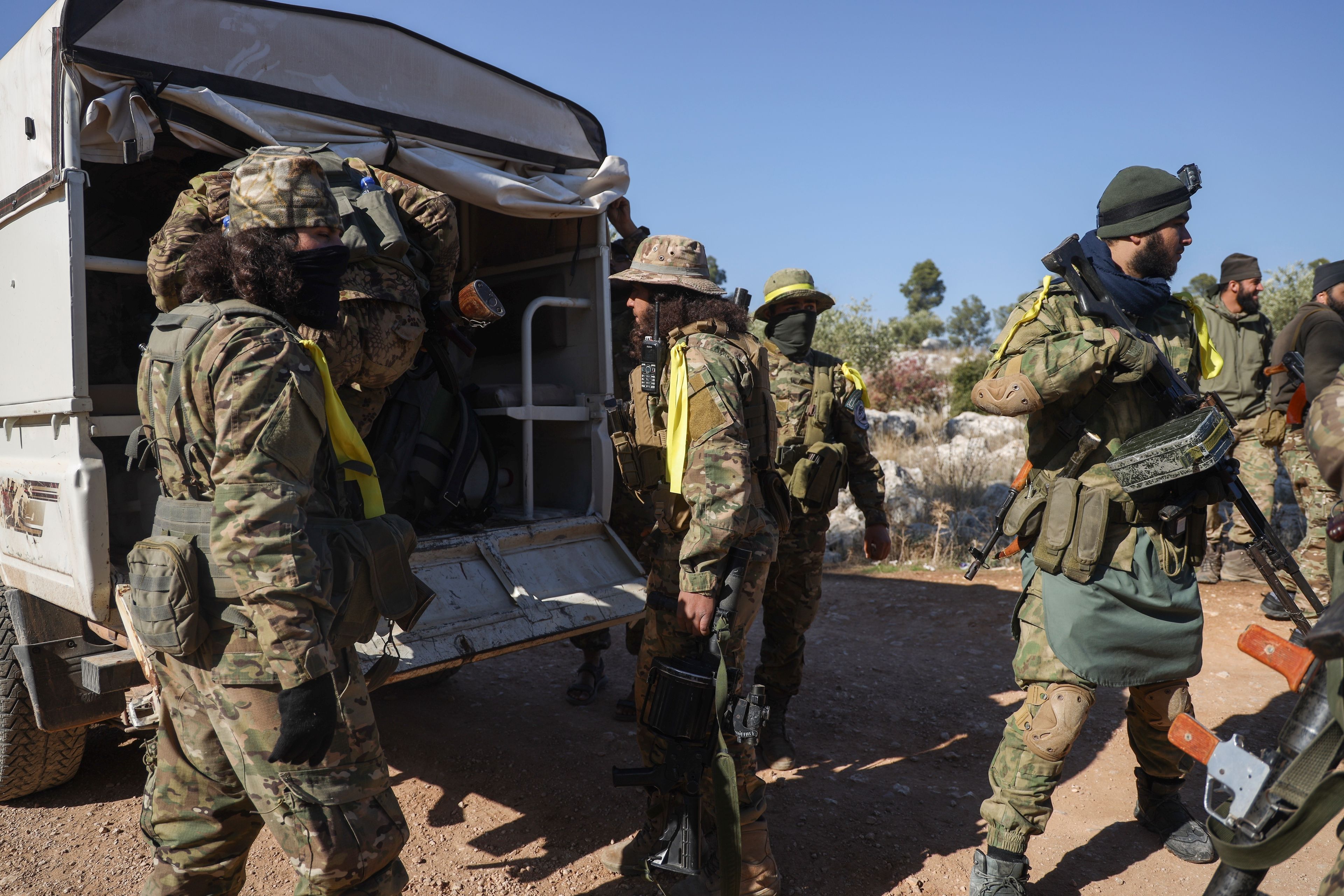 Syrian opposition fighters get off a truck as they enter the village of Anjara, western outskirts of Aleppo, Syria, Thursday Nov. 28, 2024, part of their major offensive on government-controlled areas in the country's northwestern Syria. (AP Photo/Omar Albam)