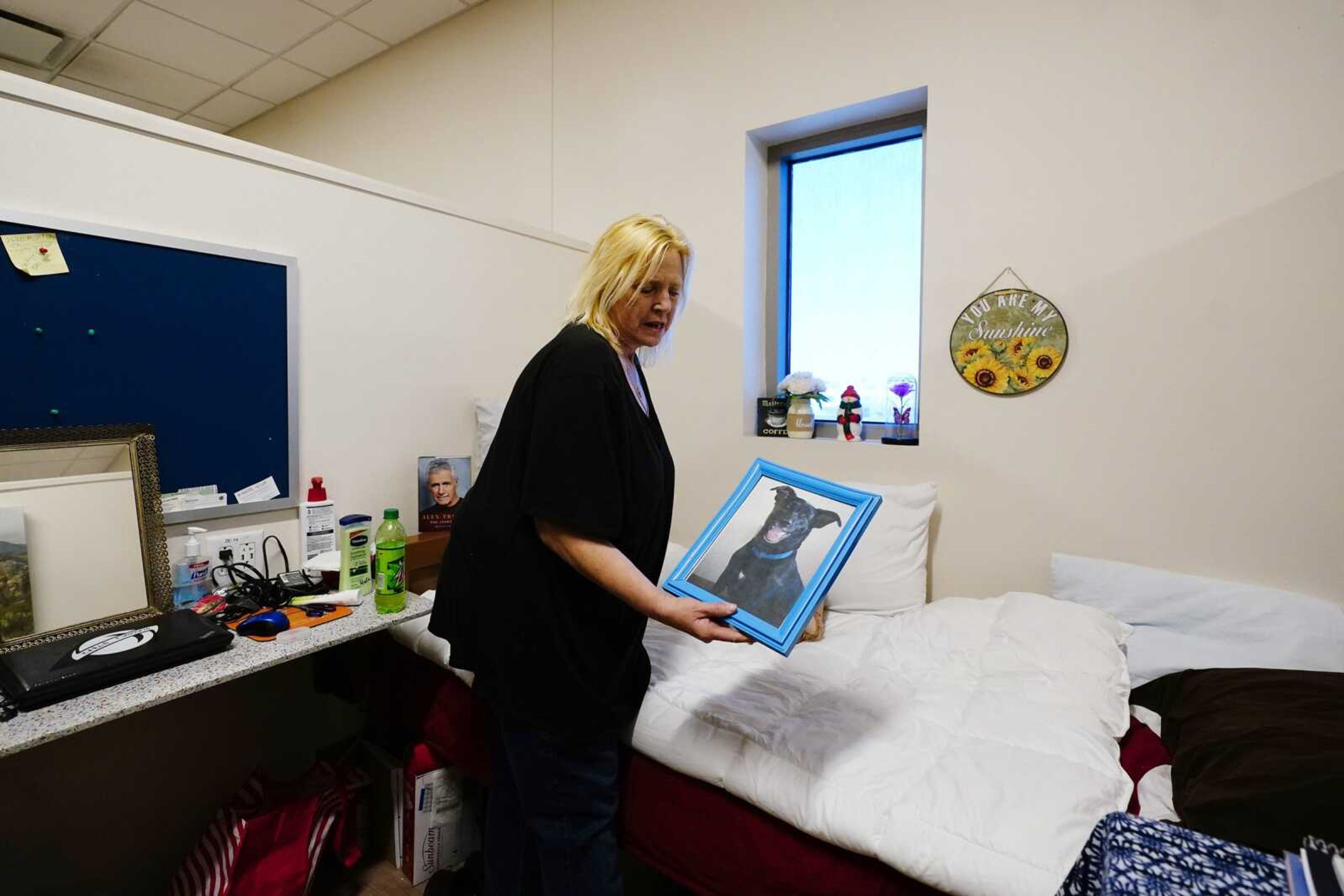 Karla Finocchio, 55, holds up a picture of her dog in her modest housing at Ozanam Manor temporary housing for people 50 and older Feb. 4 in Phoenix. Finocchio is one face of America's graying homeless population, a rapidly expanding group of destitute and desperate people 50 and older suddenly without a permanent home after a job loss, divorce, family death or health crisis during the pandemic.