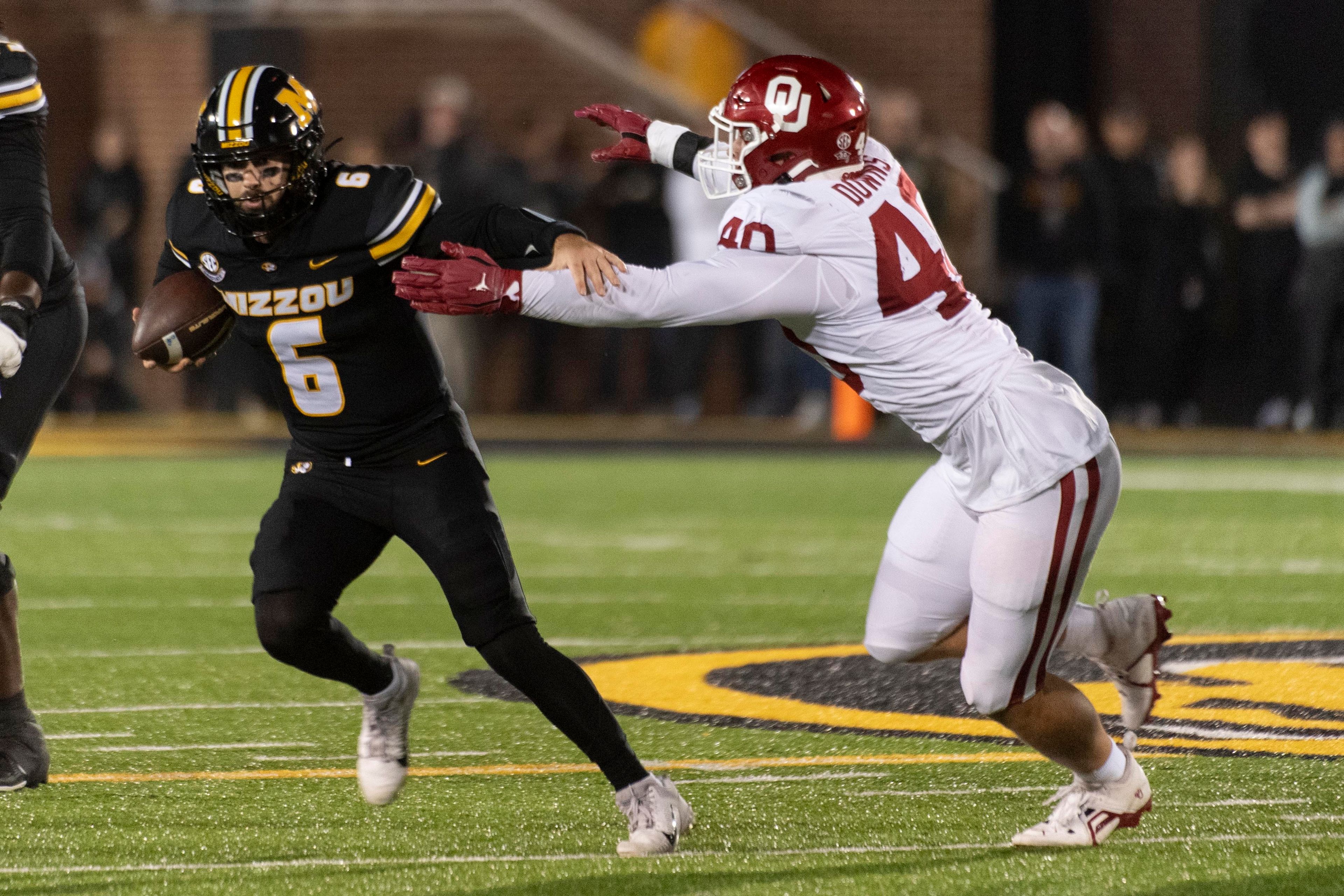 Missouri quarterback Drew Pyne (6) runs from Oklahoma defensive lineman Ethan Downs during the first half of an NCAA college football game Saturday, Nov. 9, 2024, in Columbia, Mo. (AP Photo/L.G. Patterson)