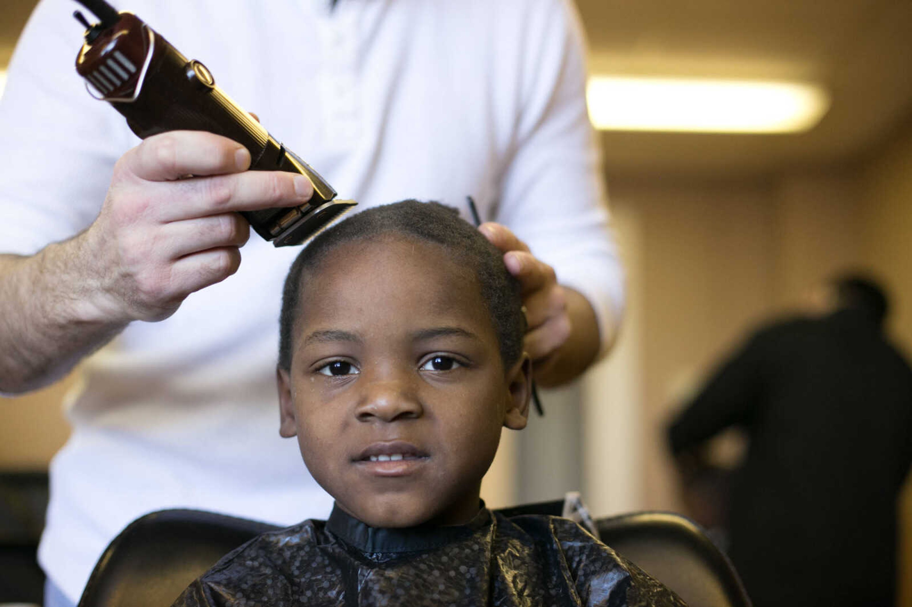 GLENN LANDBERG ~ glandberg@semissourian.com

Qualandrius Murray receives a trim from Justin Mouser before having his family photo taken during the Help-Portrait event at the House of Hope Saturday, Dec. 5, 2015 in Cape Girardeau. The one day event gives families the opportunity to get their hair and make-up done, a photo session and prints for free, all in the same day.