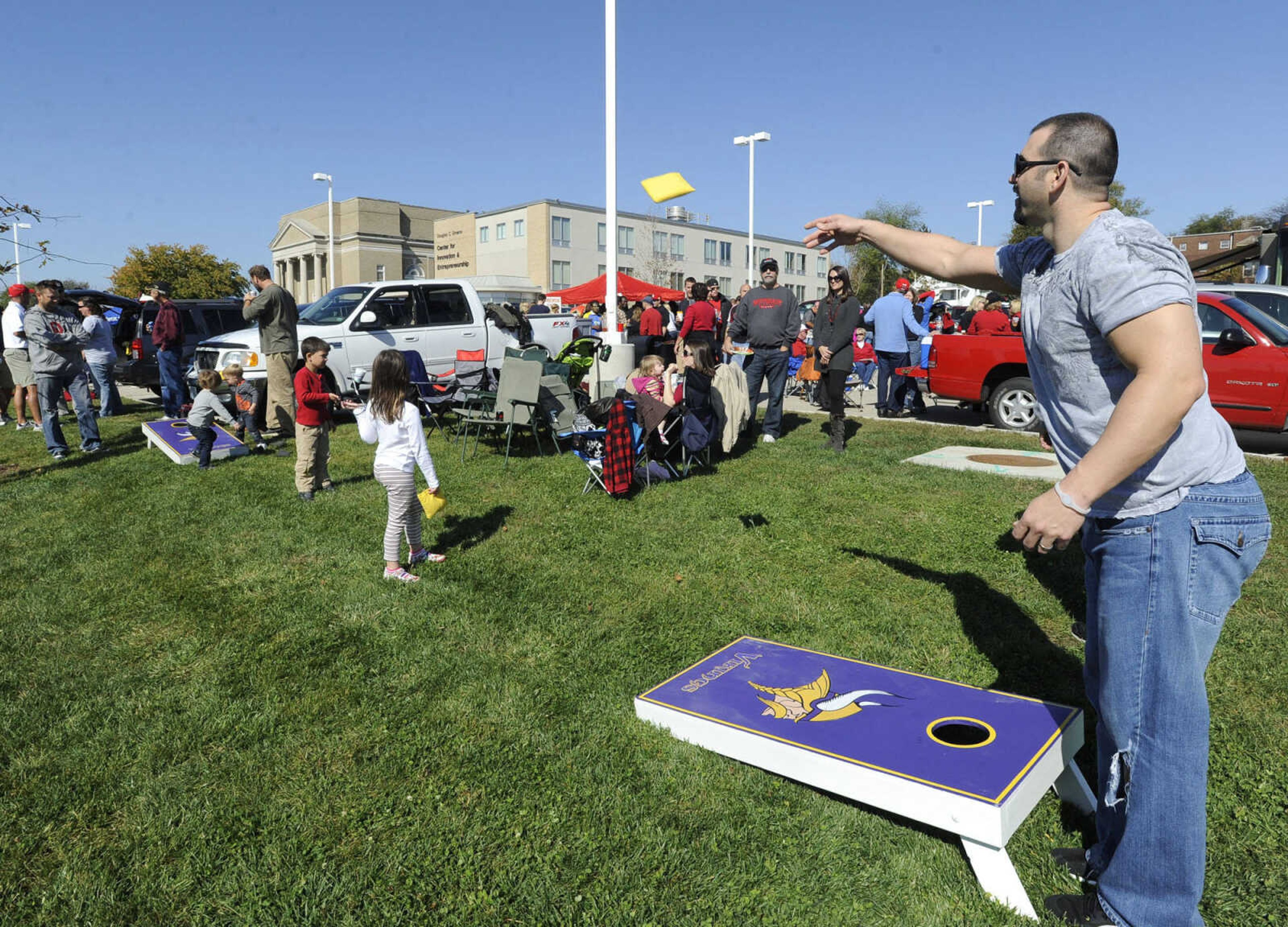 Josh Stephens tosses a beanbag at a tailgate party after the homecoming parade.