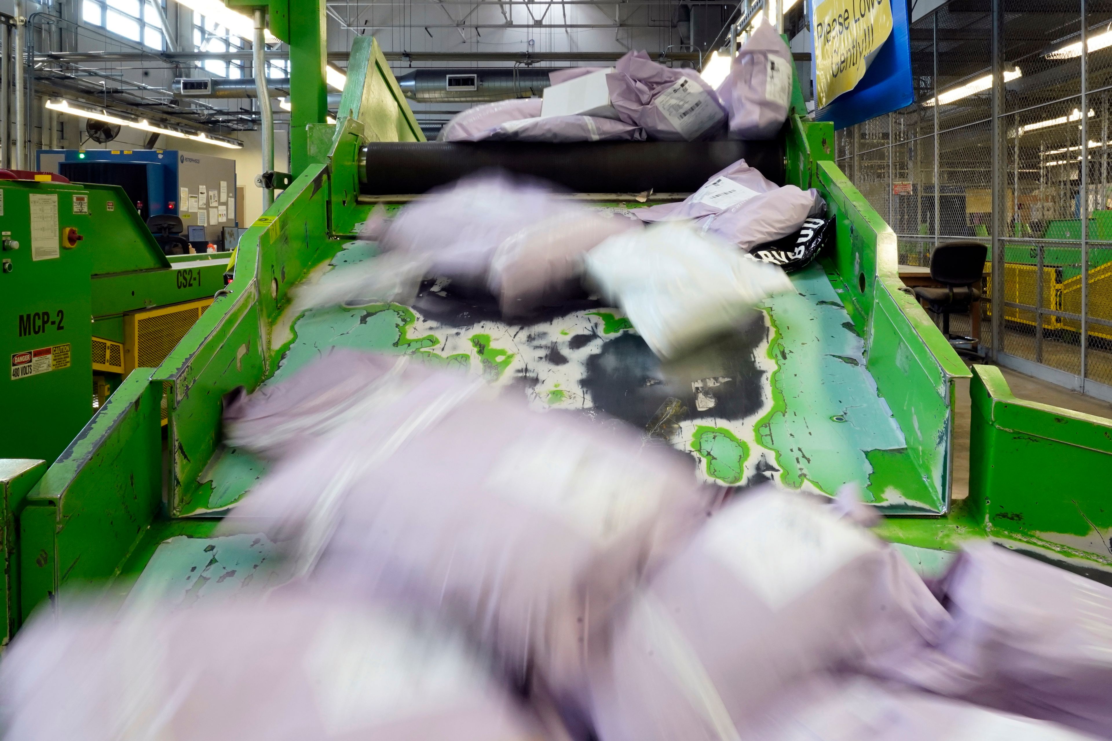 FILE - Parcels slide down a ramp after being scanned at the U.S. Customs and Border Protection overseas mail inspection facility at Chicago's O'Hare International Airport Feb. 23, 2024, in Chicago. (AP Photo/Charles Rex Arbogast, File)