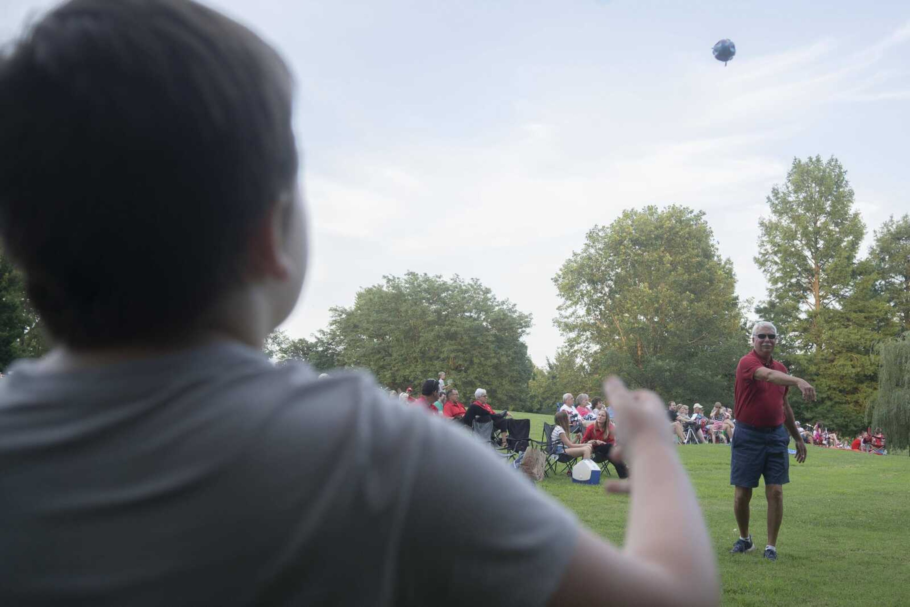 David Halter, right, tosses a football to his grandson, Lawson Burgfeld, 10, during an Independence Day celebration at the Jackson Municipal Band Shell.