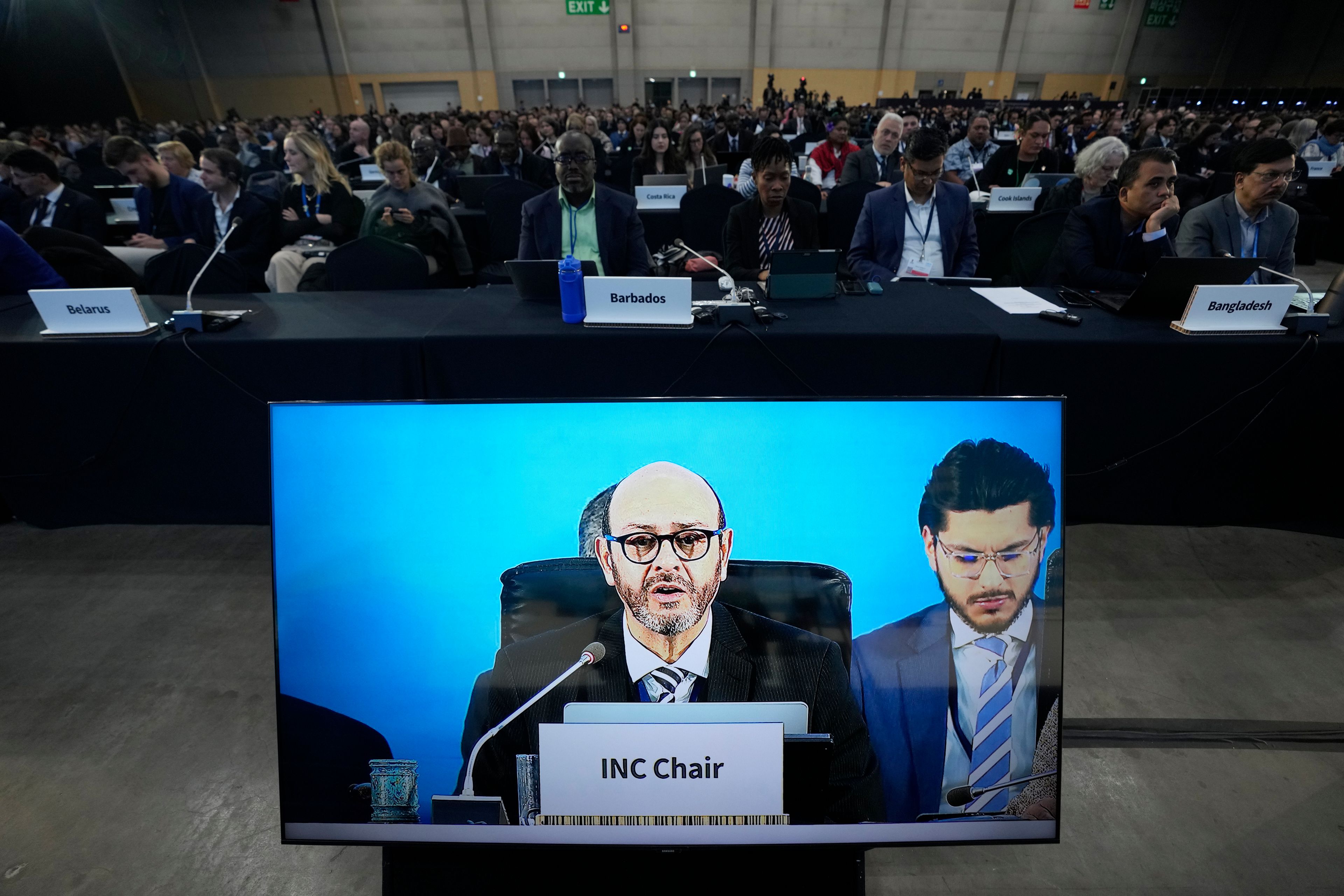 Chair of the International Negotiating Committee, Luis Vayas Valdivieso, on the screen, speaks during a plenary of the fifth session of the Intergovernmental Negotiating Committee on Plastic Pollution in Busan, South Korea, Sunday, Dec. 1, 2024. (AP Photo/Ahn Young-joon)