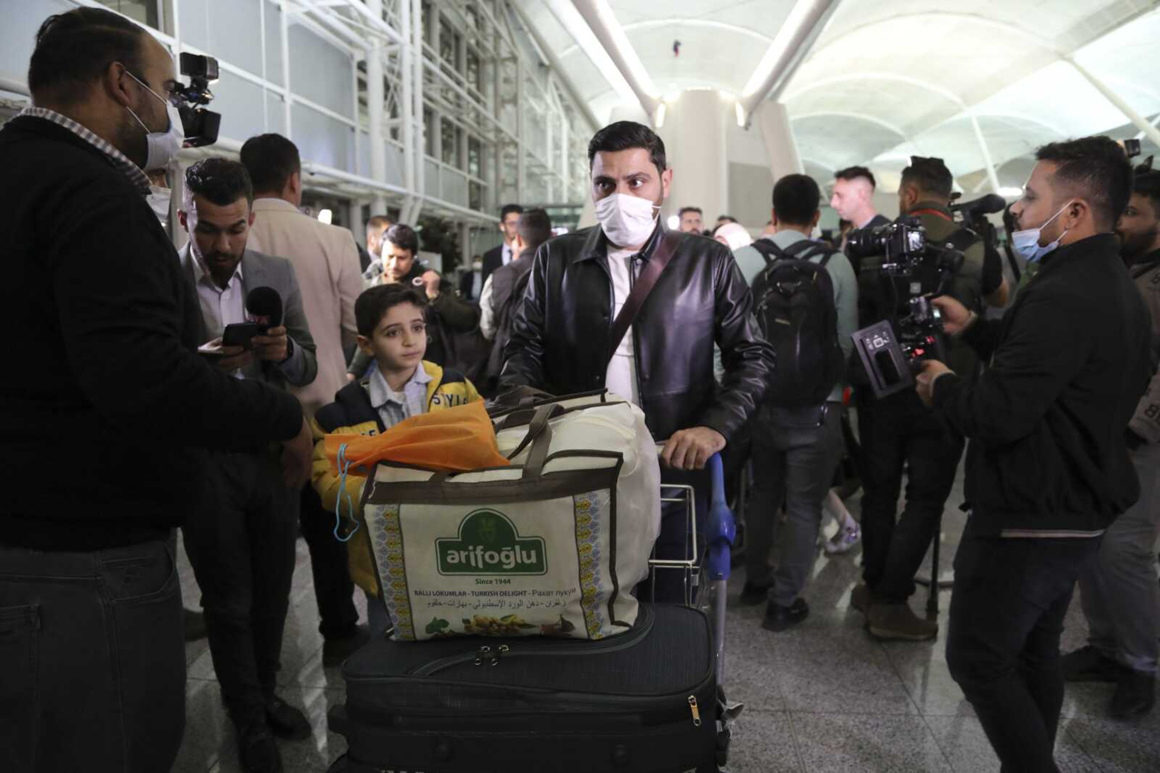 Iraqi migrants arrive to the airport Thursday in Irbil, Iraq.