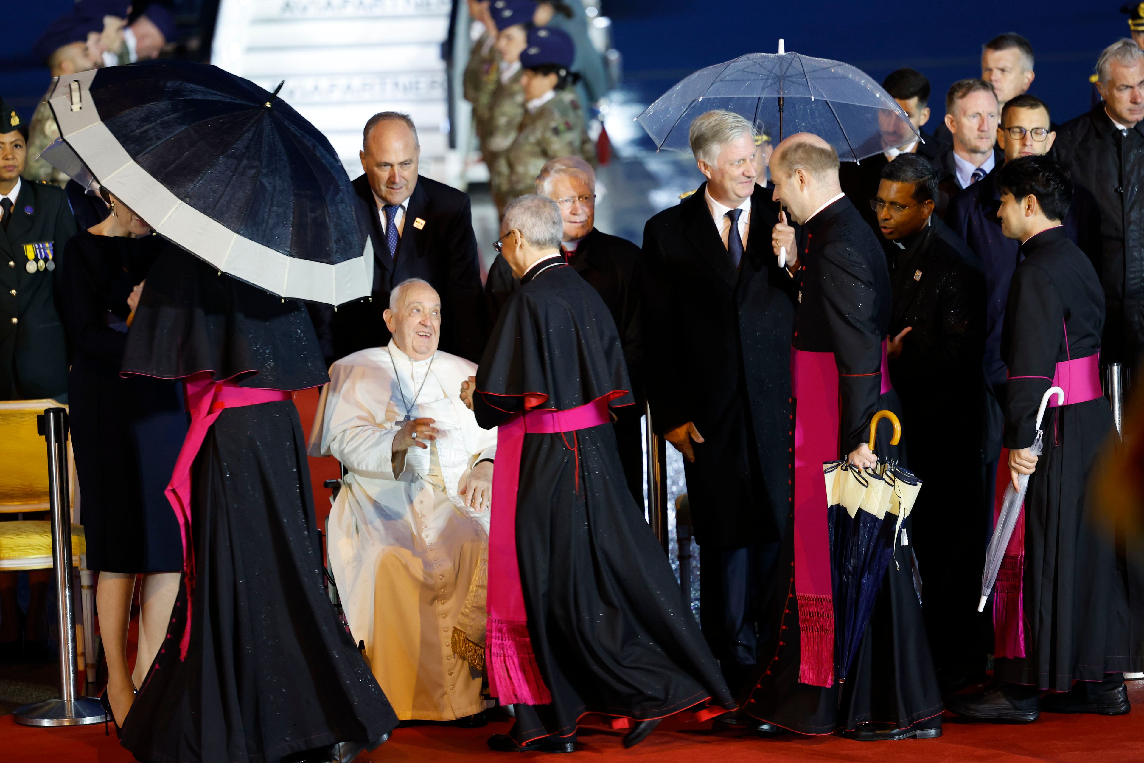 Pope Francis is welcomed by bishops at the Melsbroek air base in Steenokkerzeel, near Brussels, on the first day of his four-day visit to Luxembourg and Belgium, Thursday, Sept. 26, 2024. (AP Photo/Geert Vanden Wijngaert)