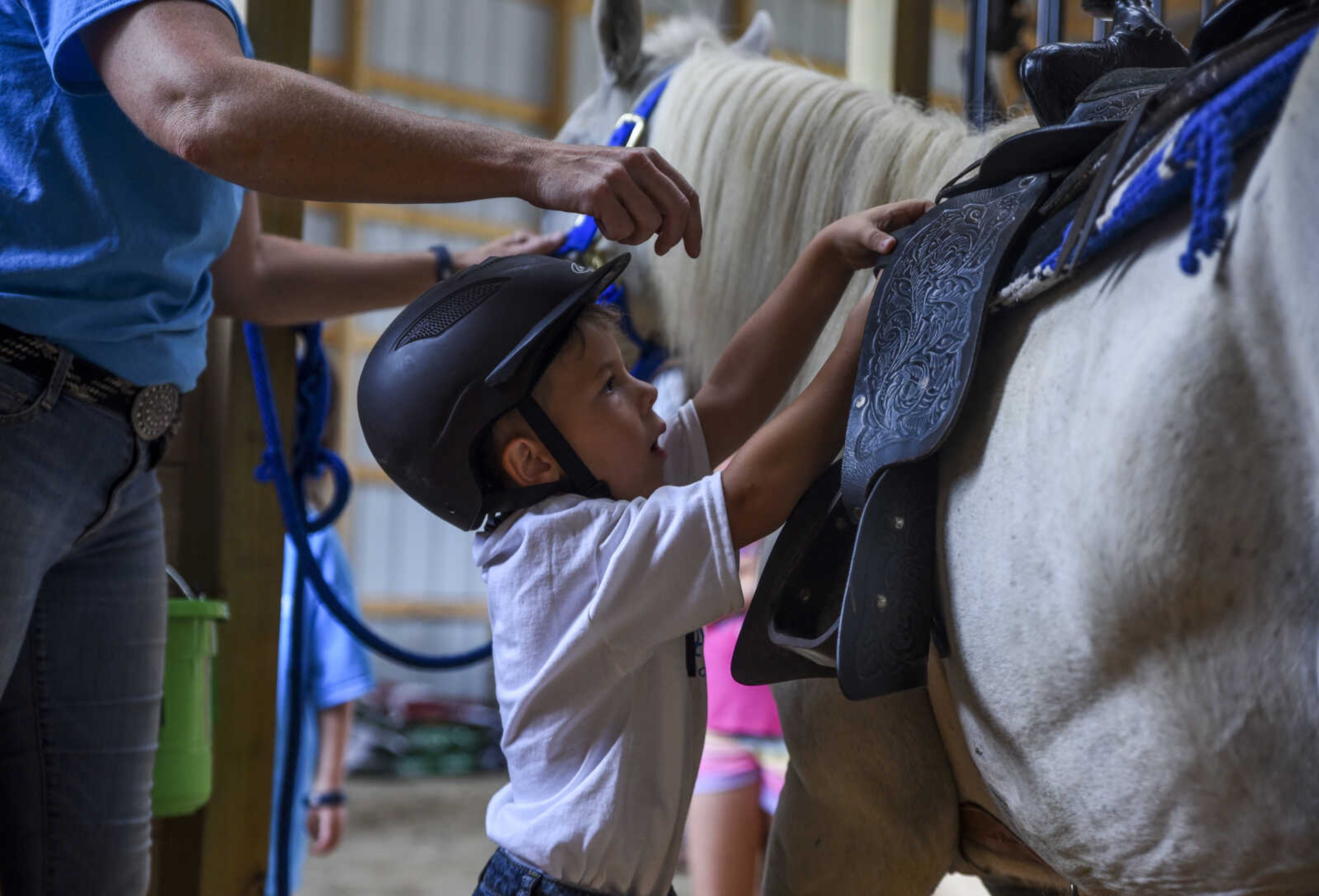 Nate Prichard, 5, takes the saddle of his new horse Silver with the guidance of Varina Luttrull, program director for Mississippi Valley Therapeutic Horsemanship, Monday, July 30, 2018 in&nbsp;Burfordville.