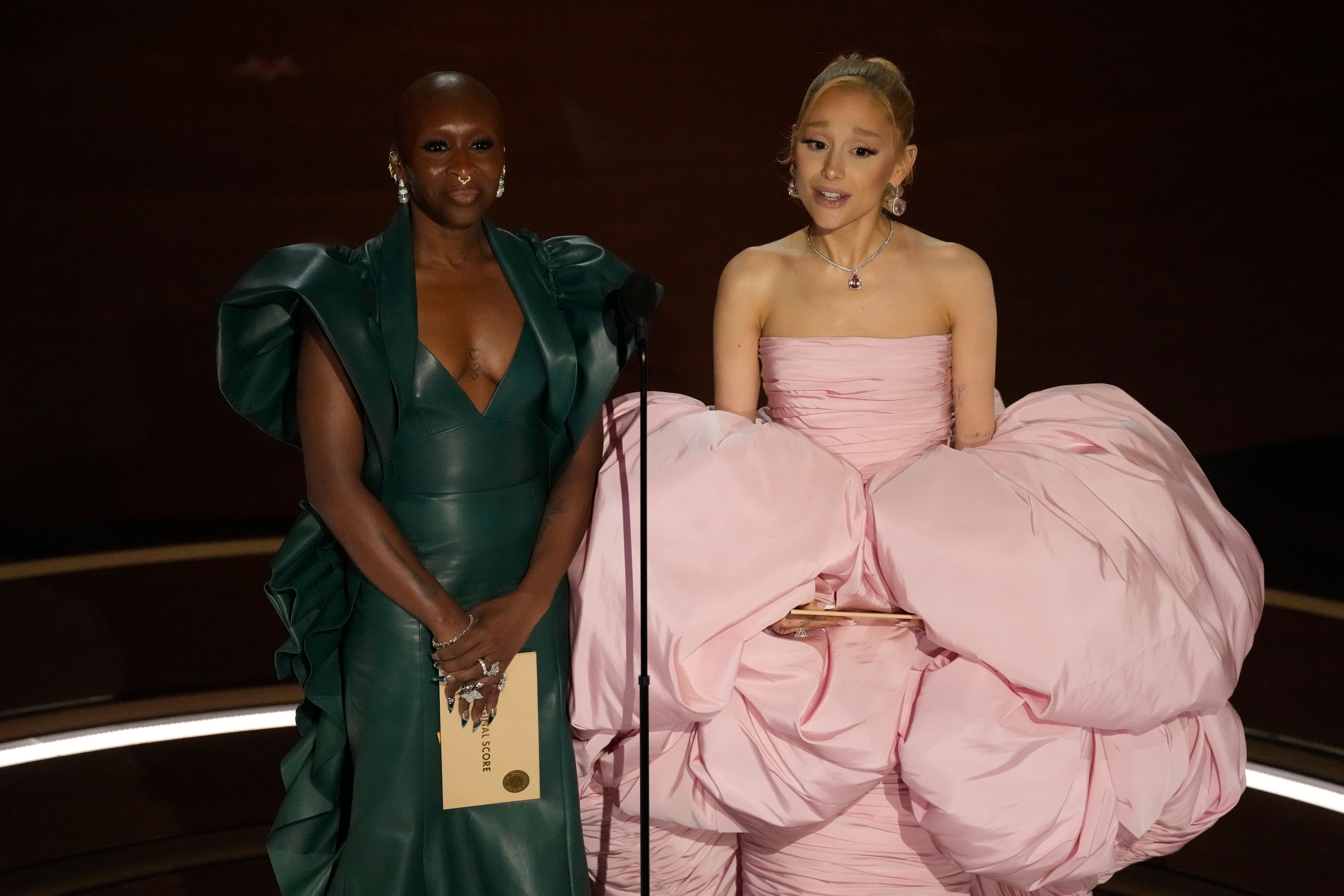 FILE - Cynthia Erivo, left, and Ariana Grande present the award for best original song during the Oscars on Sunday, March 10, 2024, at the Dolby Theatre in Los Angeles. In “Wicked,” Elphaba and Glinda travel from Shiz University to the Emerald City on a glistening green train to meet the wizard. In real life, Cynthia Erivo and Ariana Grande have traveled much farther and wider and longer and on airplanes to promote their hotly anticipated film. (AP Photo/Chris Pizzello, File)