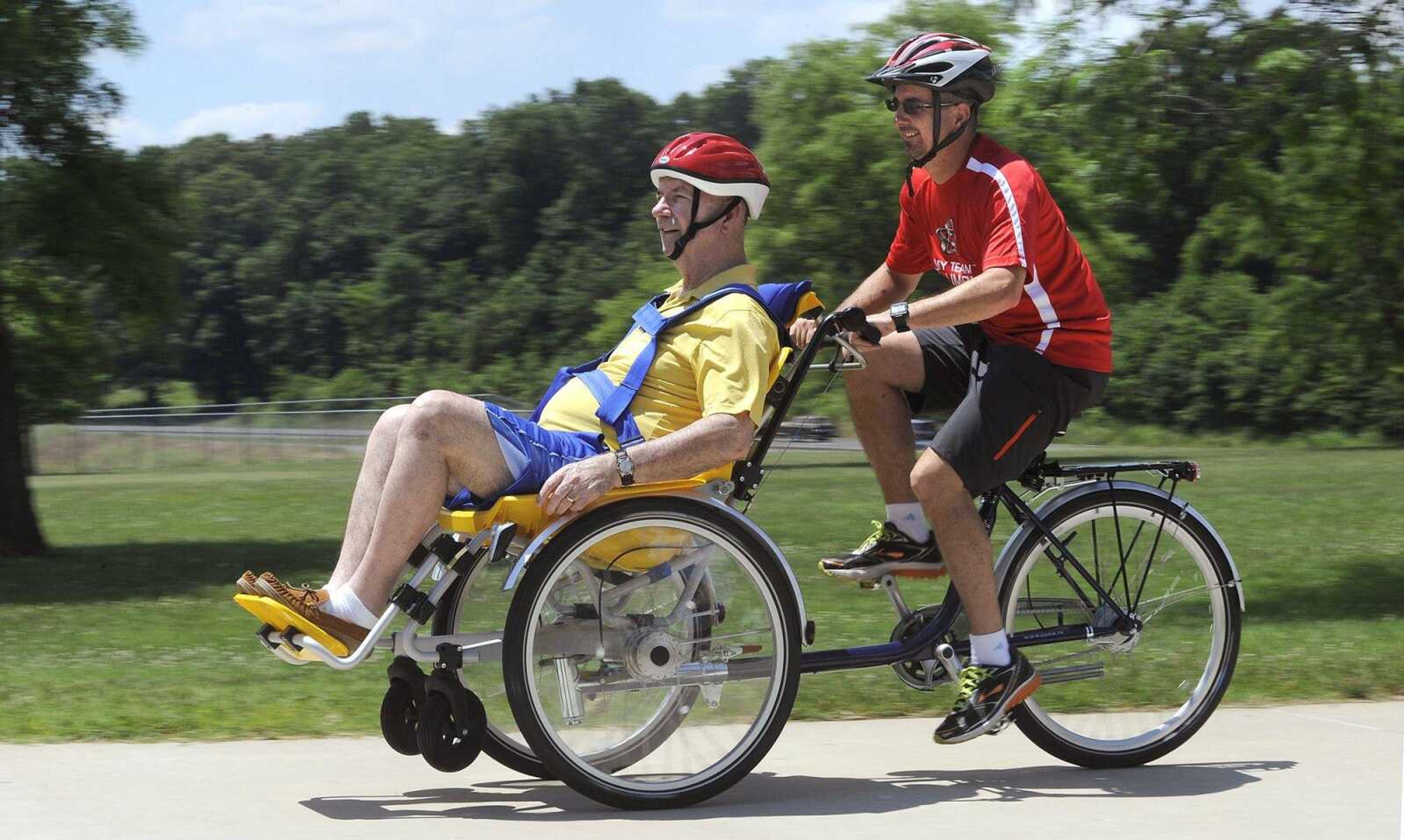 Dan Mueller takes a ride in a wheelchair bicycle tandem with his driver, Derrick Dean, during a picnic Saturday at the Missouri Veterans Home in Cape Girardeau.