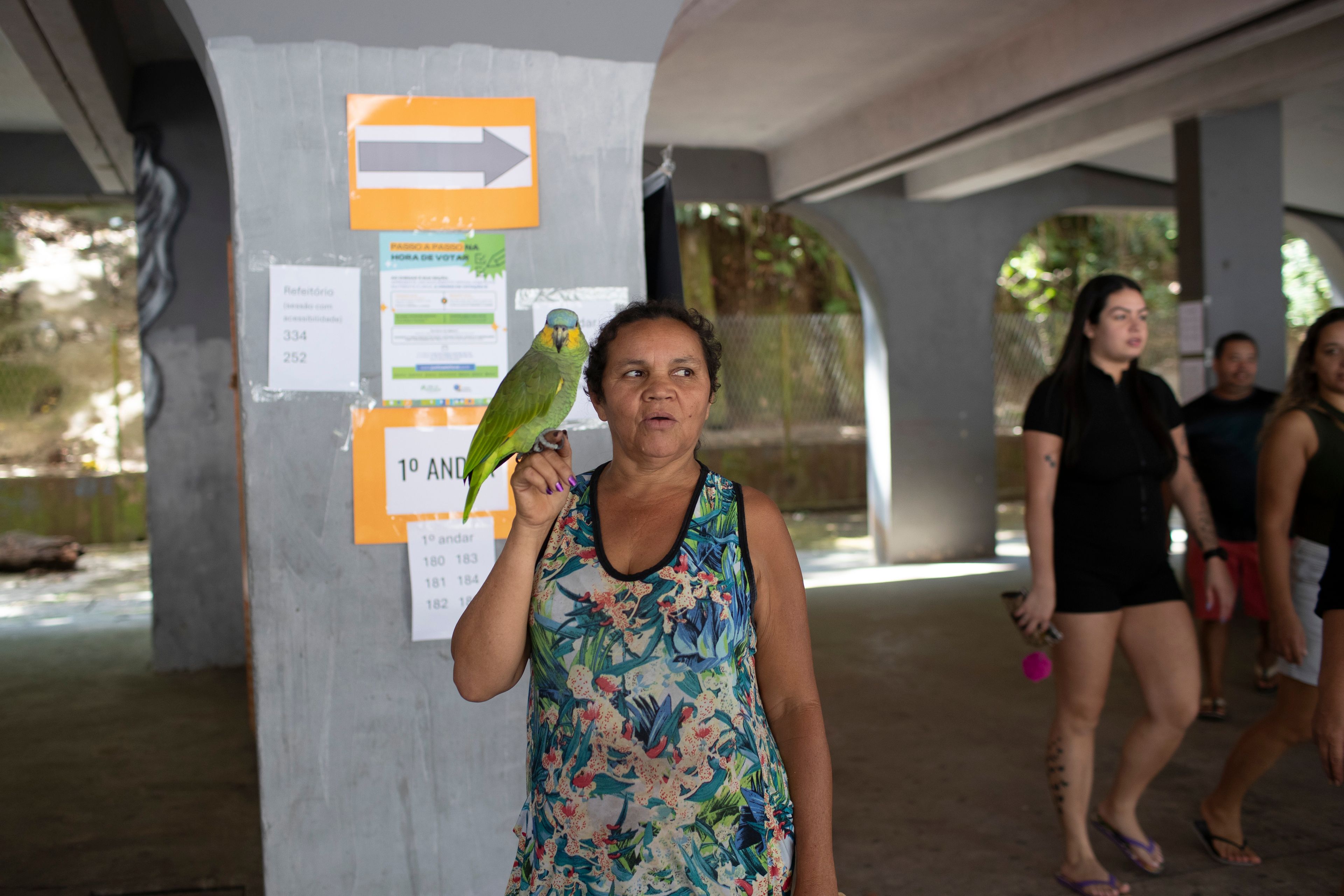 Tereza Domingos holds her parrot Noninho after voting in the municipal elections in the Rocinha community of Rio de Janeiro, Sunday, Oct. 6, 2024. (AP Photo/Bruna Prado)