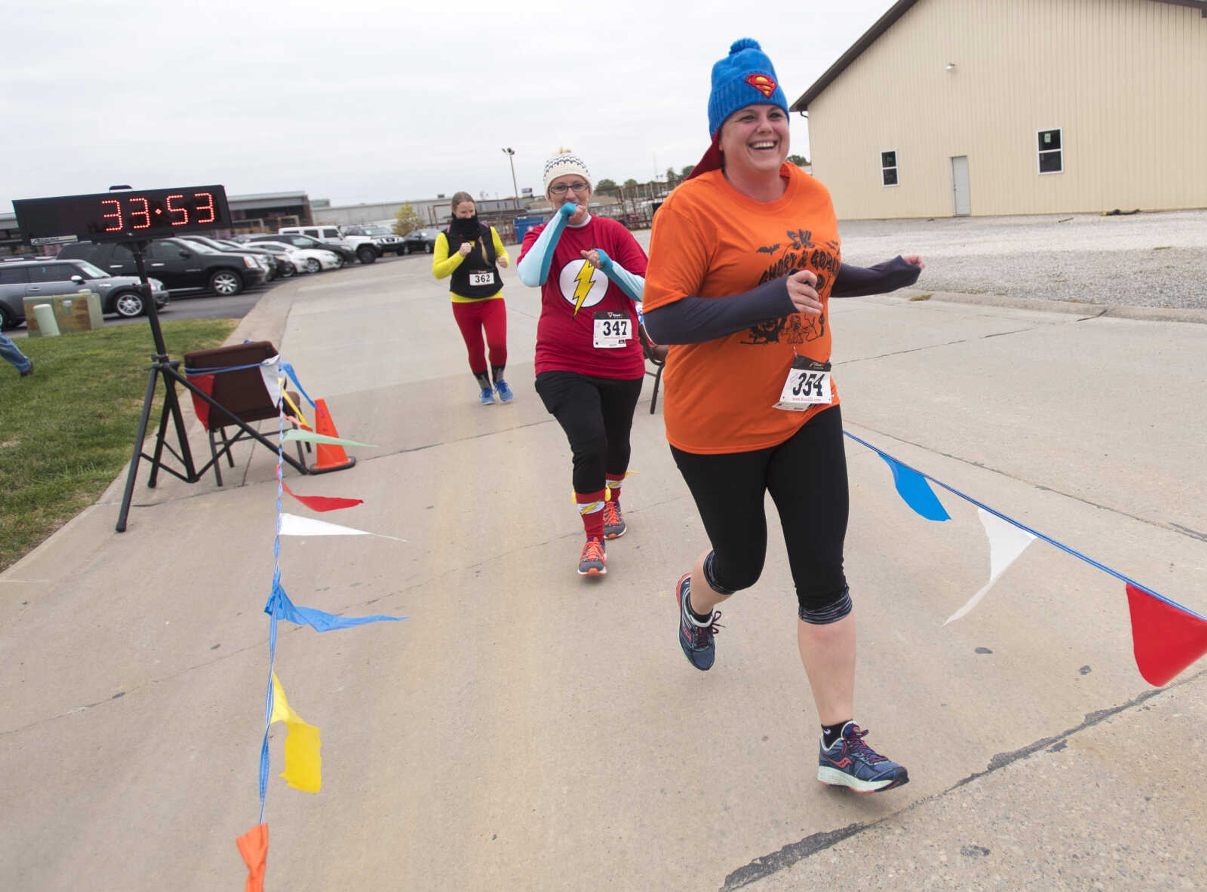 From left, Gretchen Probst, Jennifer Auer and Jennifer Monroe cross the finish line during the first Ghost and Goblin Gallop 5k race to raise money for the Crossroads Backpack Fair on Saturday, Oct. 28, 2017 in Jackson.