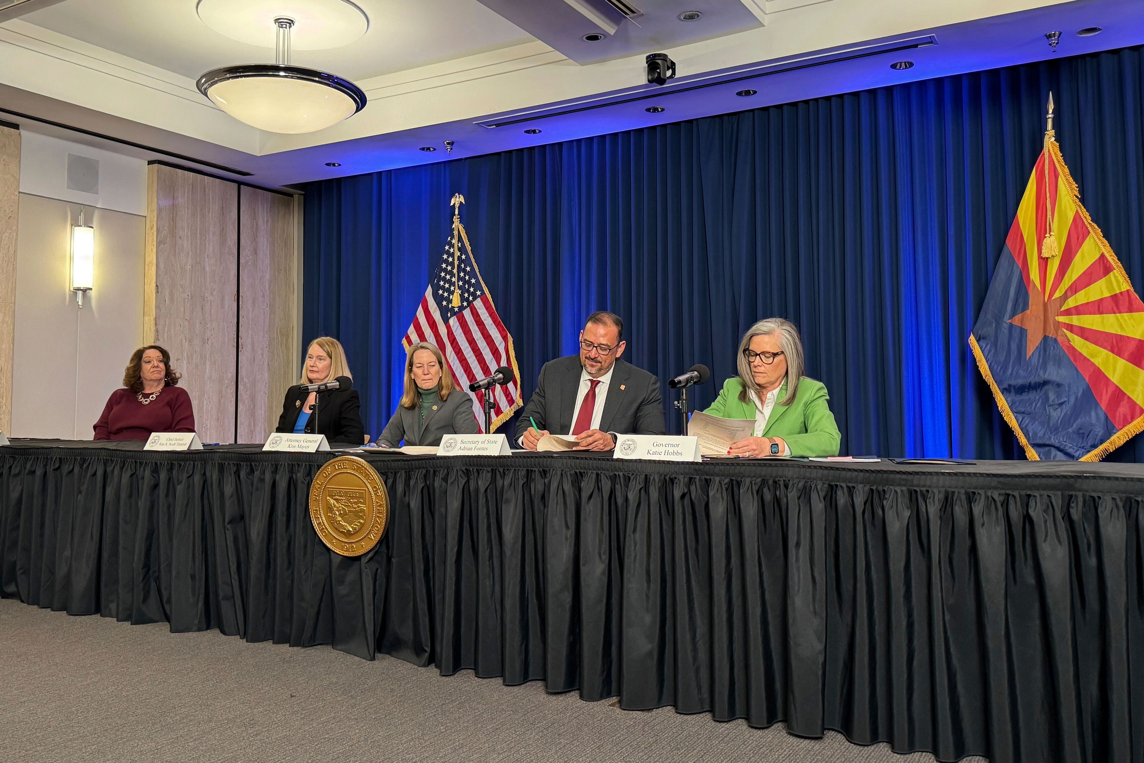 Arizona Gov. Katie Hobbs, right, and Secretary of State Adrian Fontes sign off on election results as state Attorney General Kris Mayes, Arizona Supreme Court Chief Justice Ann Timmer and state election director Lisa Marra look on during the state canvassing meeting in Phoenix, Monday, Nov. 25, 2024. (AP Photo/Gabriel Sandoval)