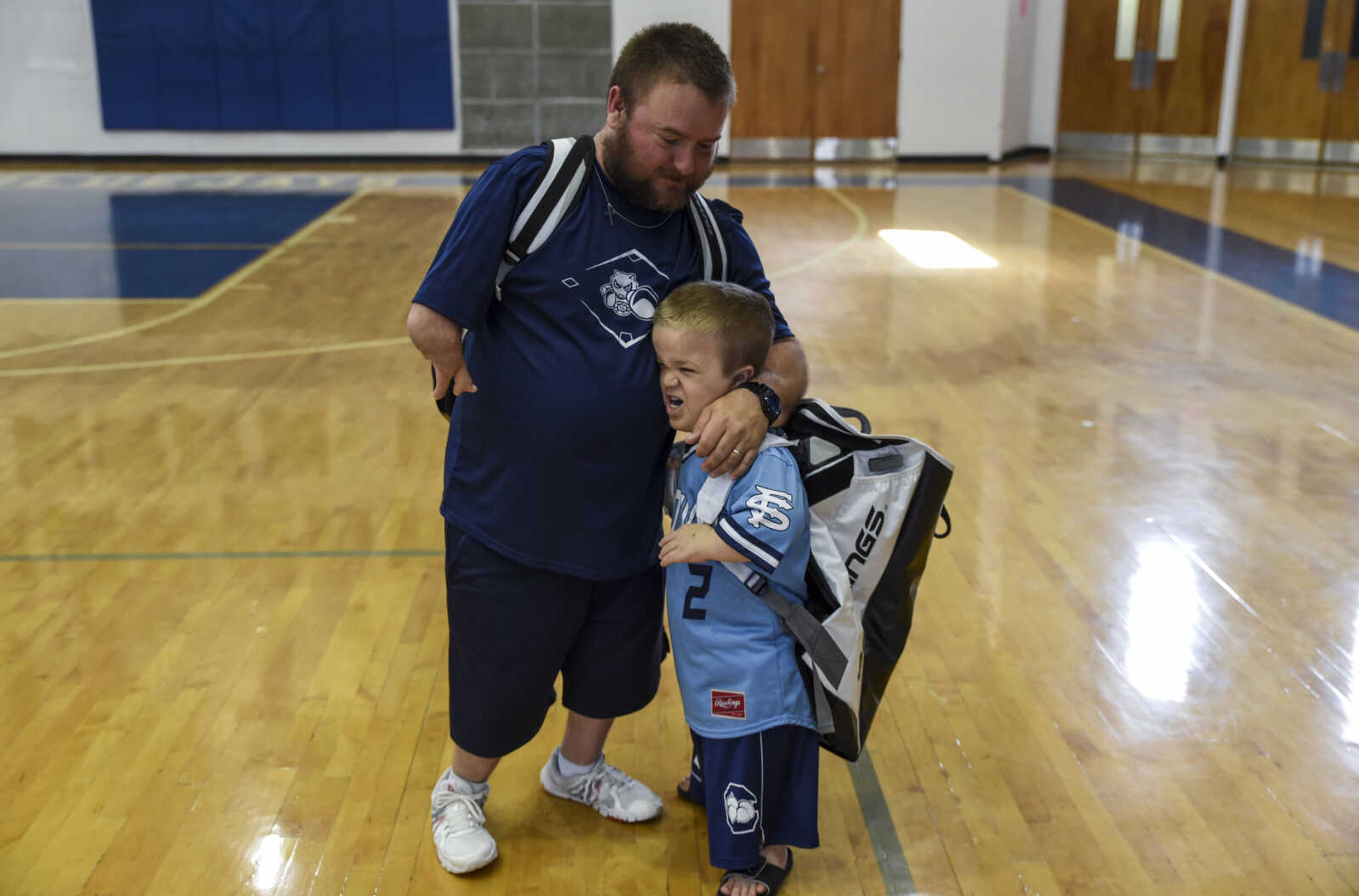 Izaac Pursley hugs Charleston Fighting Squirrels baseball team coach Michael Minner during jersey pick-up day May 6, 2018, in Charleston.