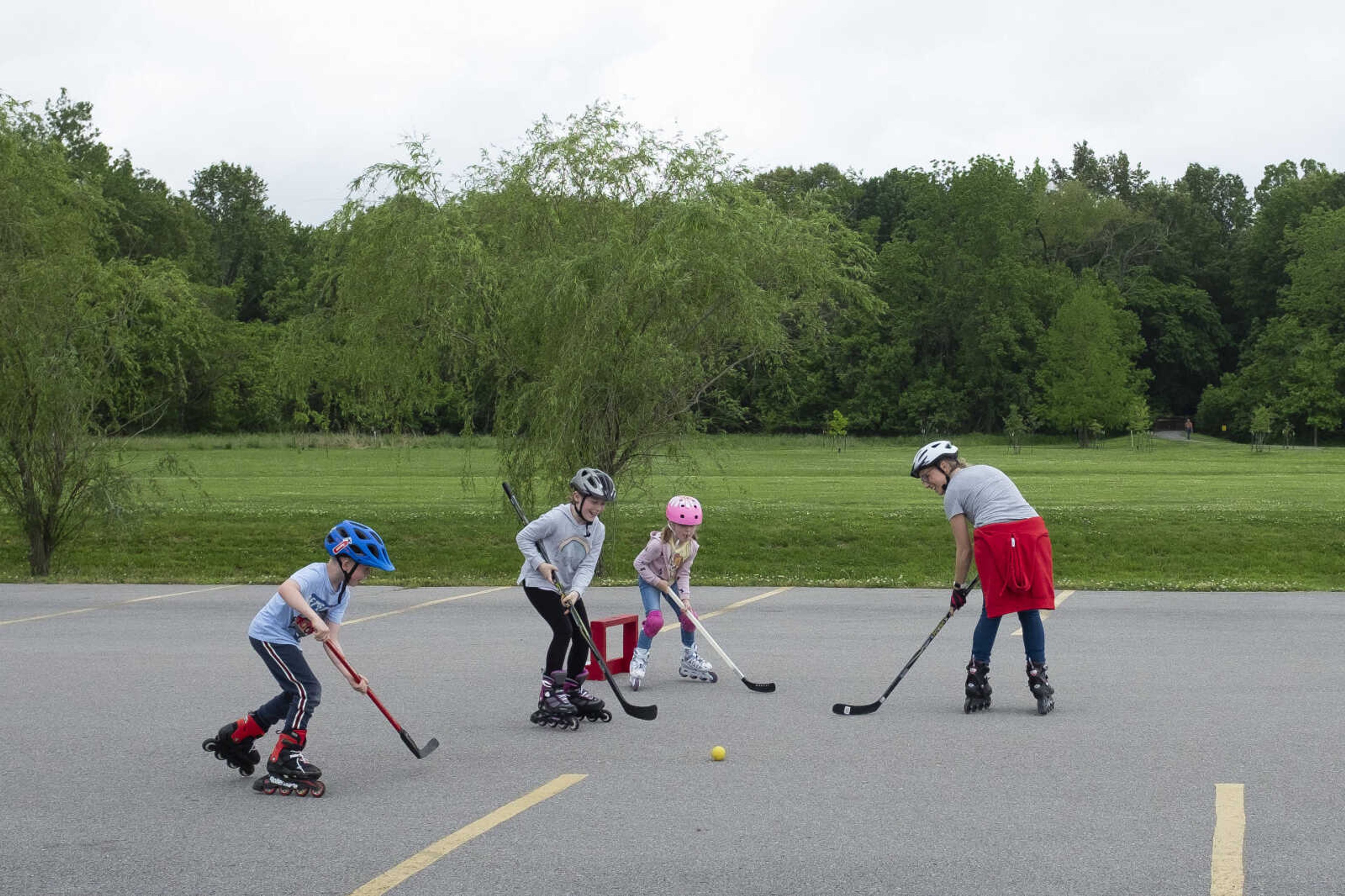 Booch family members of Cape Girardeau, from left, Henri, 7, Emma, 9, Matilda, 5, and mother Maren play hockey Wednesday, May 20, 2020, at a parking lot near Cape Splash Family Aquatic Center in Cape Girardeau.