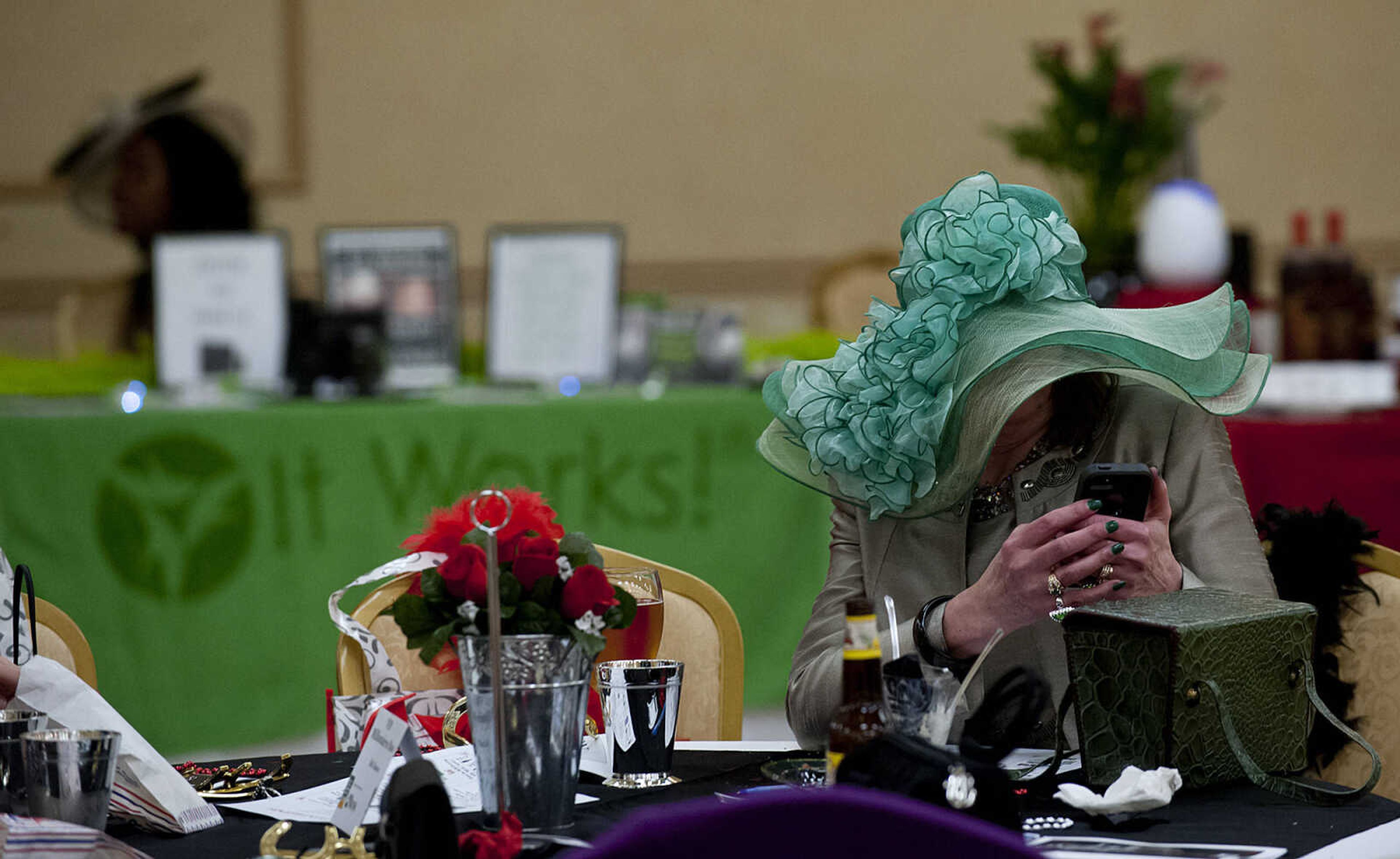 Rosalee Allgood uses her phone to post on Facebook during the Lutheran Family and Children's Services Foundation's "Boas & Bling, Kentucky Derby Party," Thursday, May 1, at The Venue in Cape Girardeau. More than 450 people attended the annual event  which is a fundraiser for the not-for-profit social services organization which provides counseling, adoption services, child care, youth mentoring services and advocacy on behalf of children and families.