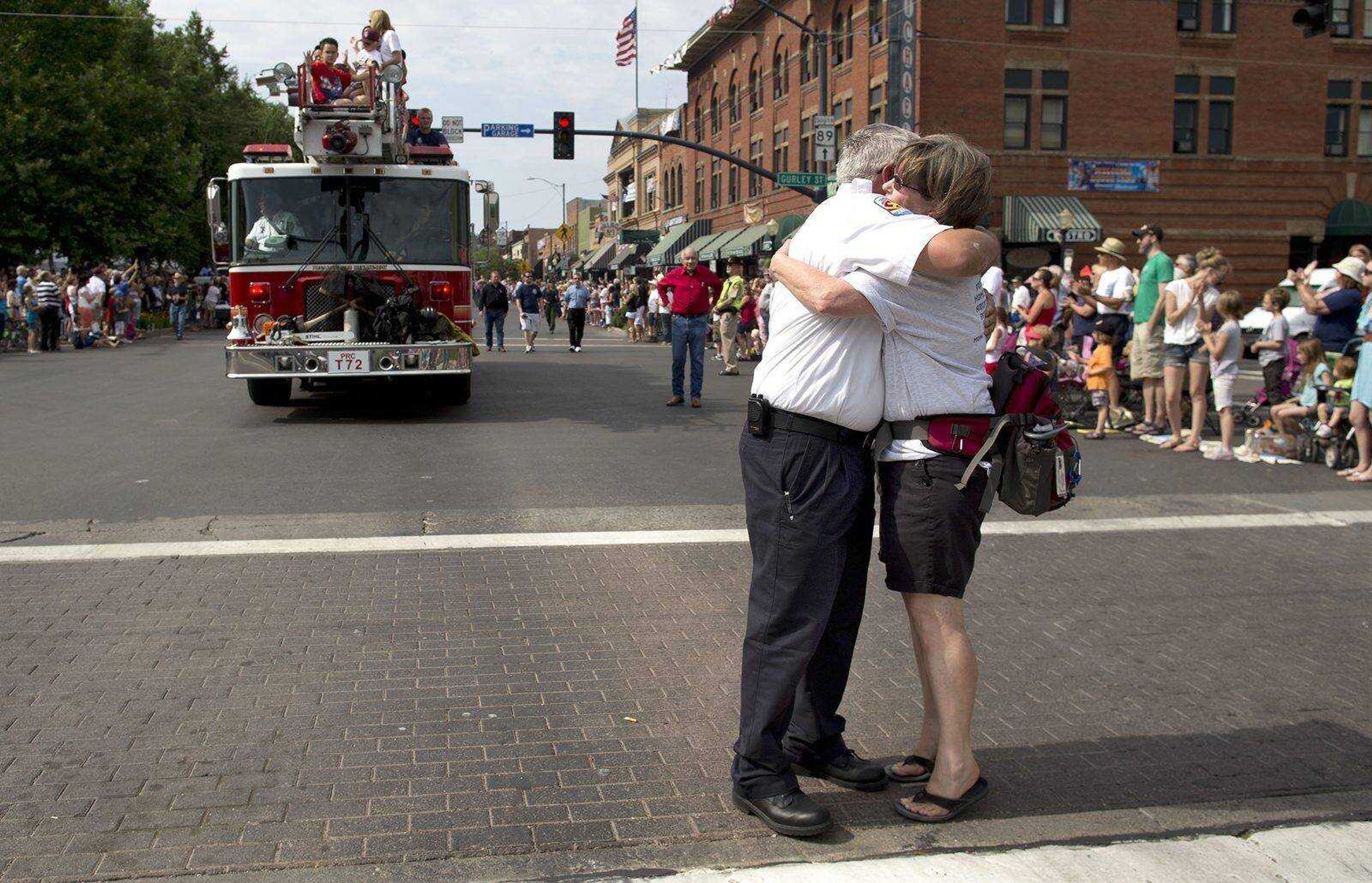 Prescott Fire Marshall Don Devendorf, left, stops to hug long-time friend Laura Halter while walking in the Prescott Frontier Days Rodeo Parade, Saturday, July 6, 2013 in Prescott, Ariz. Devendorf walked ahead of a Prescott Fire Department engine carrying family members of the 19 Granite Mountain Hotshot firefighters who were killed last week fighting a fire near Yarnell, Ariz. (AP Photo/Julie Jacobson)