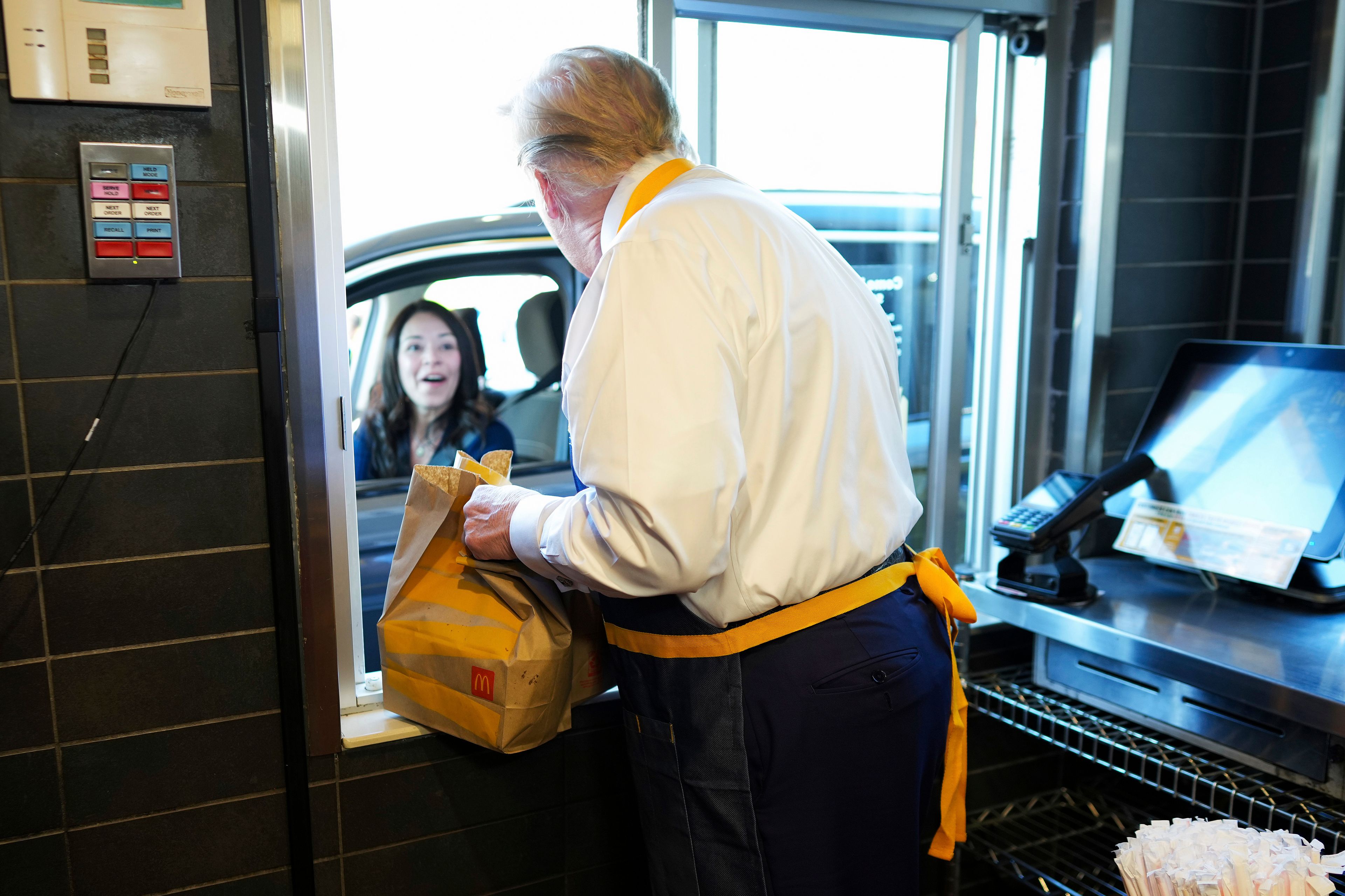 Republican presidential nominee former President Donald Trump hands an order to an employee at the drive-thru window during a visit to McDonald's in Feasterville-Trevose, Pa., Sunday, Oct. 20, 2024. (Doug Mills/The New York Times via AP, Pool)