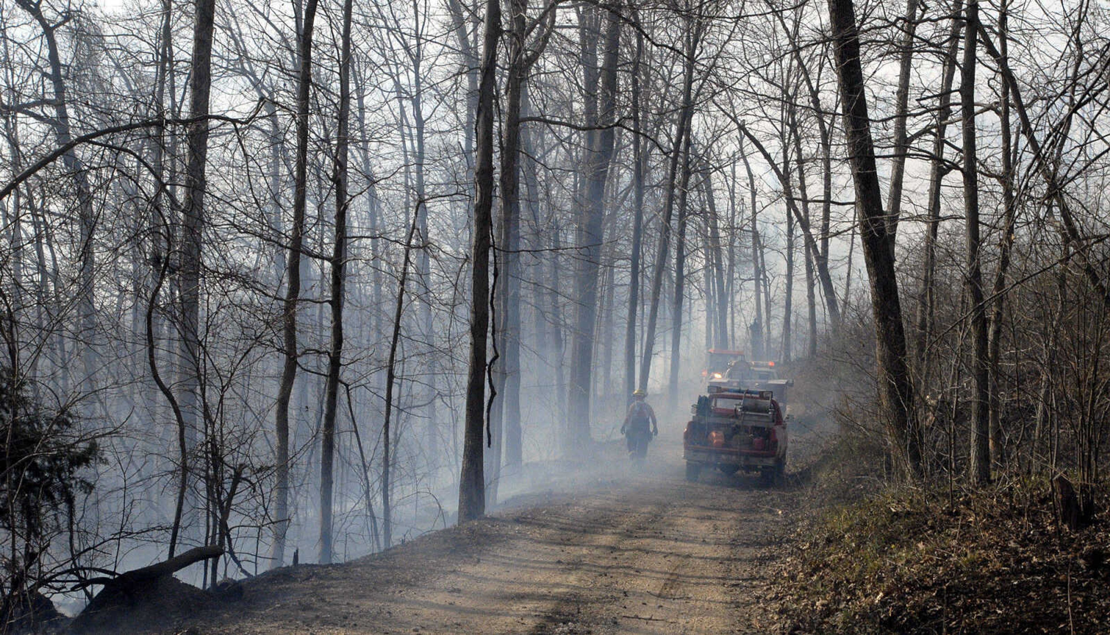 LAURA SIMON~lsimon@semissourian.com
Firefighters work to extinguish a fire on a hillside during a natural cover fire off of Cissus Lane near Neelys Landing Sunday, April 3, 2011. Firefighters from Cape Girardeau, Perry, Scott, and Bollinger Counties contained the blaze that ravaged 50 acres of land.