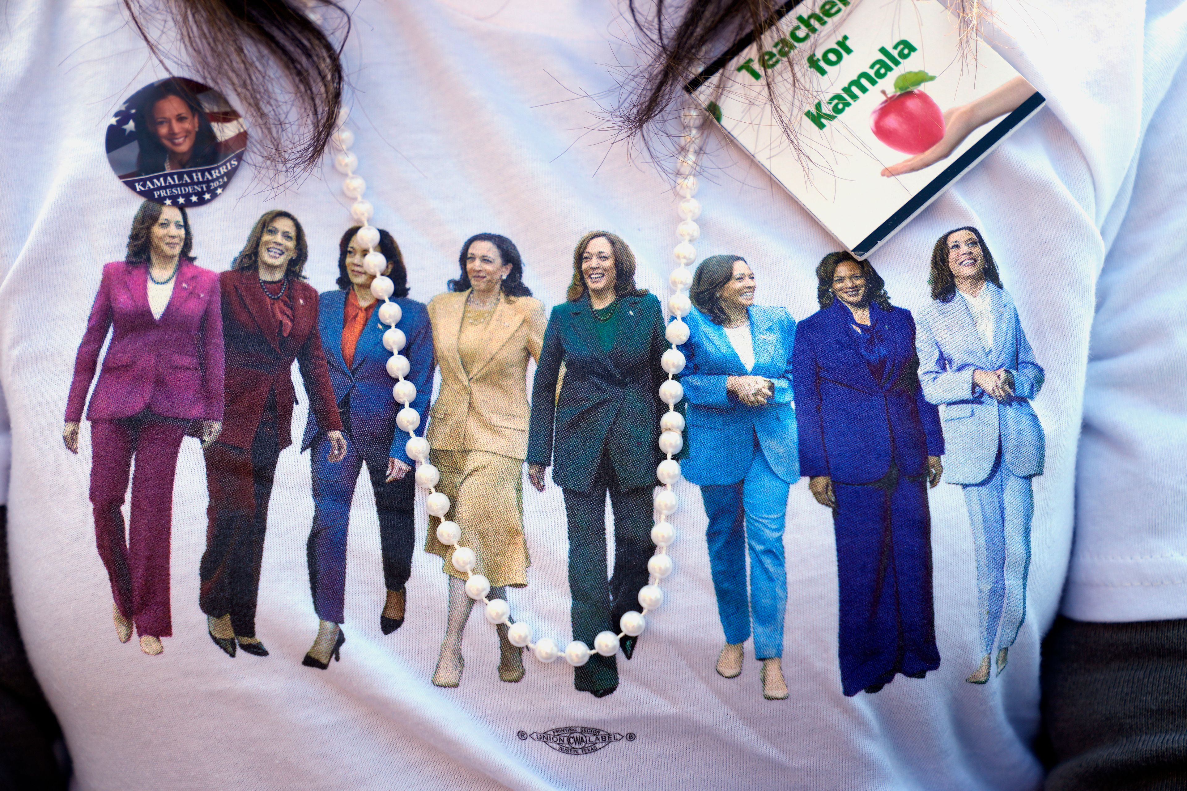 A supporter wears a campaign shirt as Democratic presidential nominee Vice President Kamala Harris speaks during a campaign event at Riverside Park in Grand Rapids, Mich., Friday, Oct. 18, 2024. (AP Photo/Jacquelyn Martin)