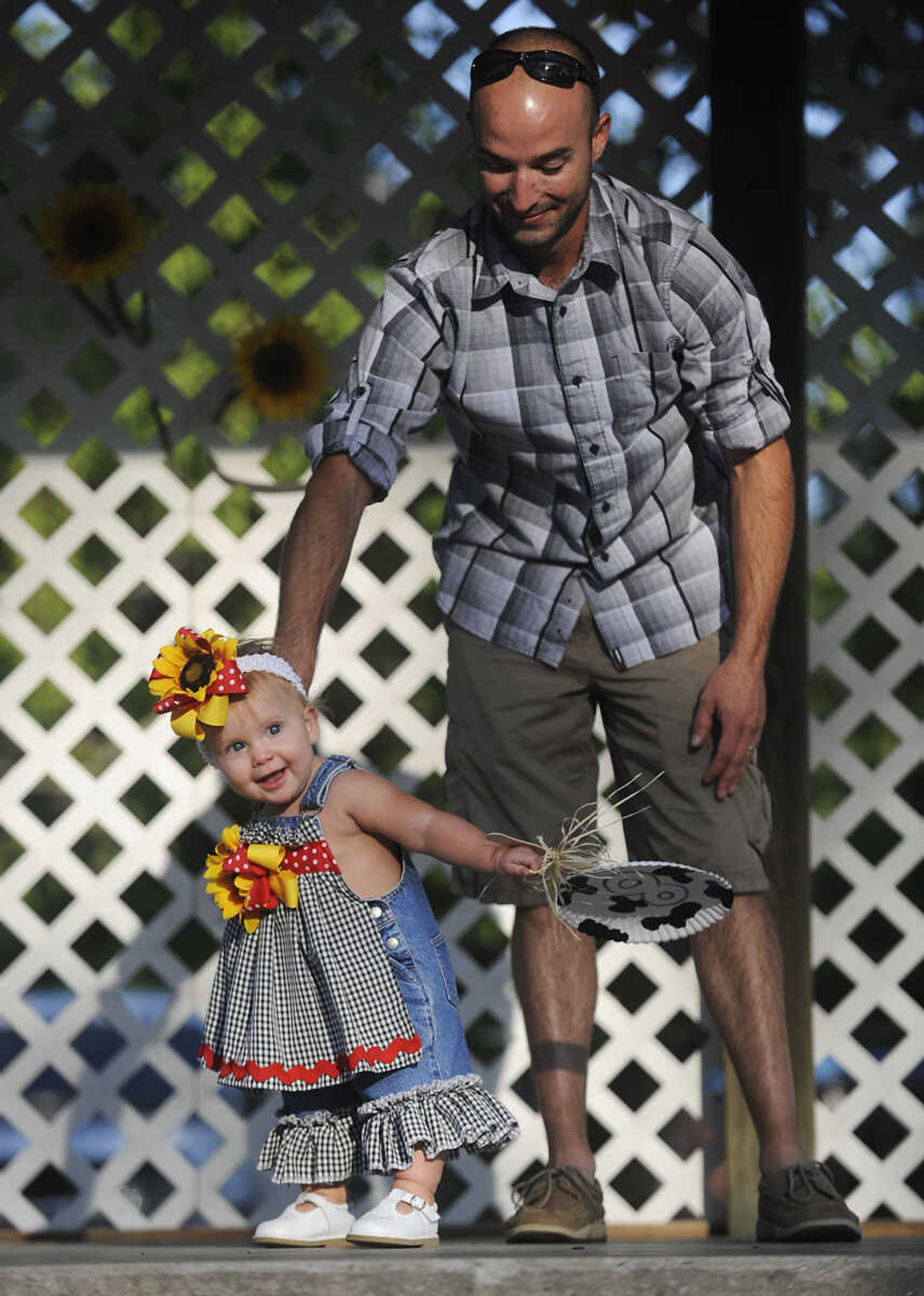 Andy, right, and Scout Sadler, 1, walk across the stage during the Mini Miss German Days Pageant during Chaffee's Annual German Days Festival Friday, August 10, at Frisco Park. Scout took first place in the pageant.