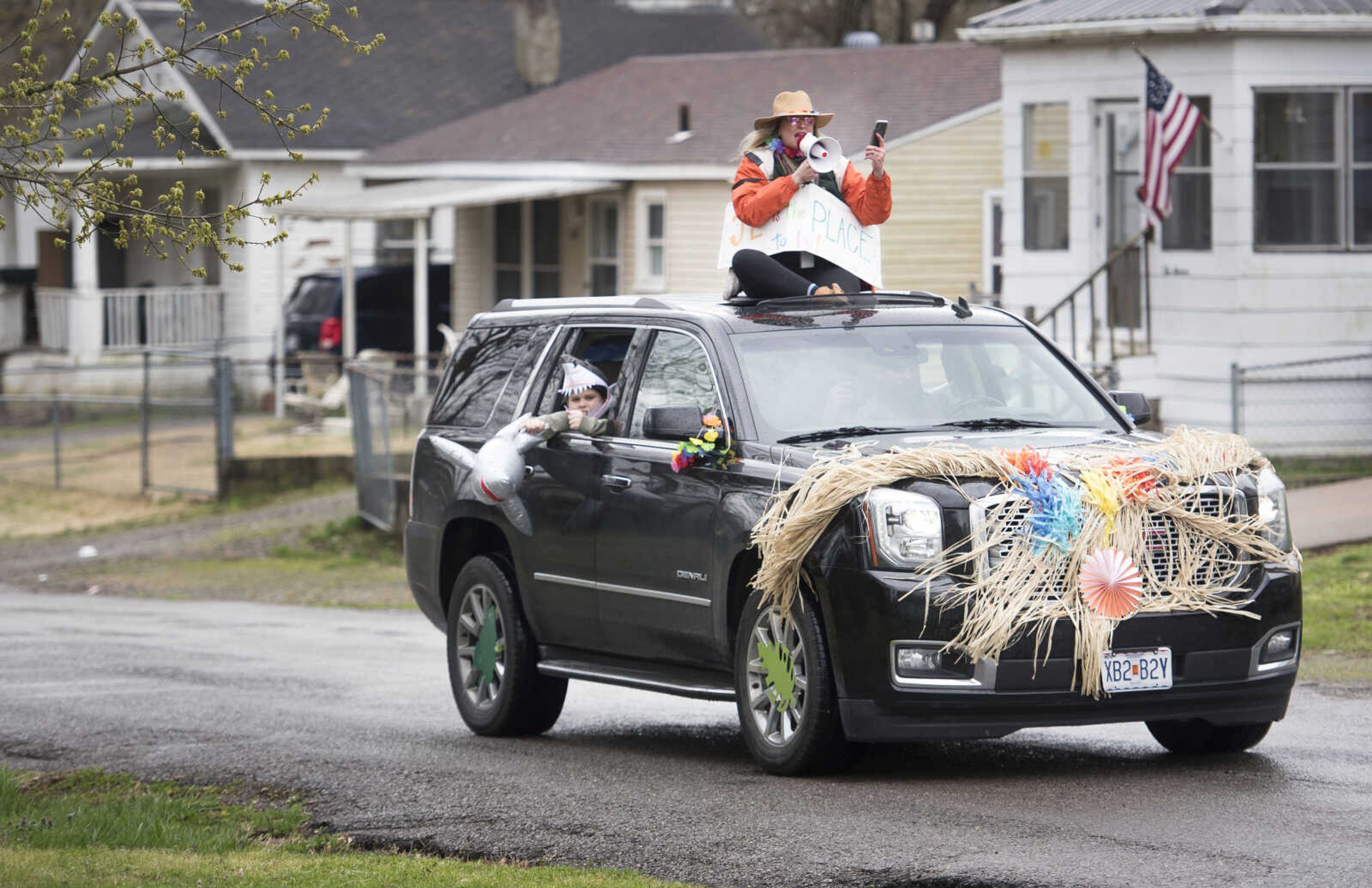 Jefferson Elementary School principal Leigh Ragsdale rides atop a beach-themed SUV during a teacher car parade in the 1000 block of South Pacific on Sunday, March 22, 2020, in Cape Girardeau. "The main reason we did it is because we believe human connectivity, and being connected to humans -- even if it is, you know, through a screen, or from from the car to the porch, or to the driveway, or in their cars," Ragsdale said. "It just makes people feel good seeing the people that they love."