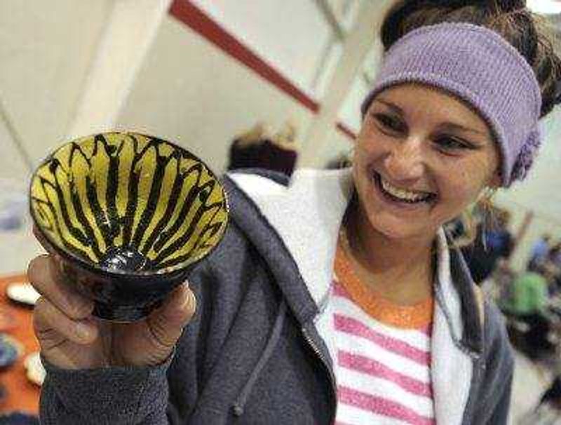 Jessi Snell examines one of the bowls available at the ninth annual Empty Bowls Banquet on Sunday at the Salvation Army Worship and Community Center in Cape Girardeau.