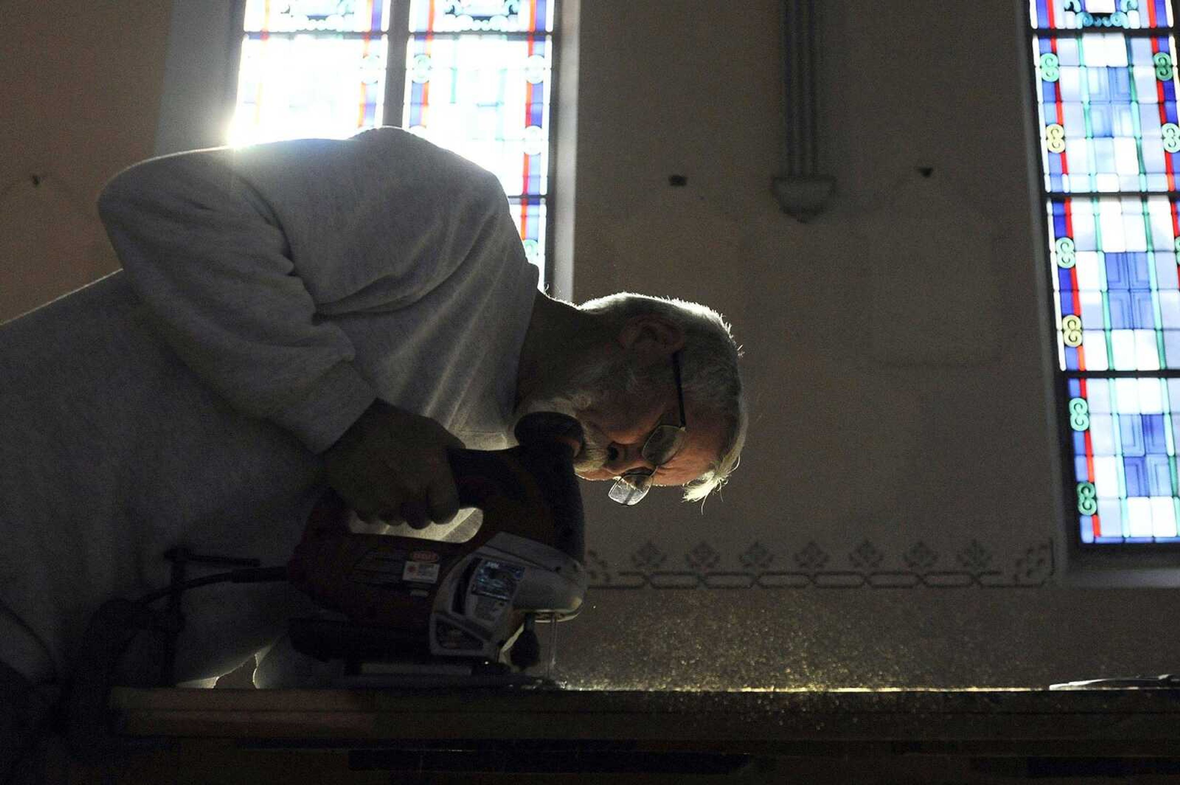 Nick Elfrink trims the base of an altar inside St. John's Catholic Church in Leopold, Missouri, on Feb. 11. Elfrink and his wife, Geri, repaired and painted the altars inside the church.