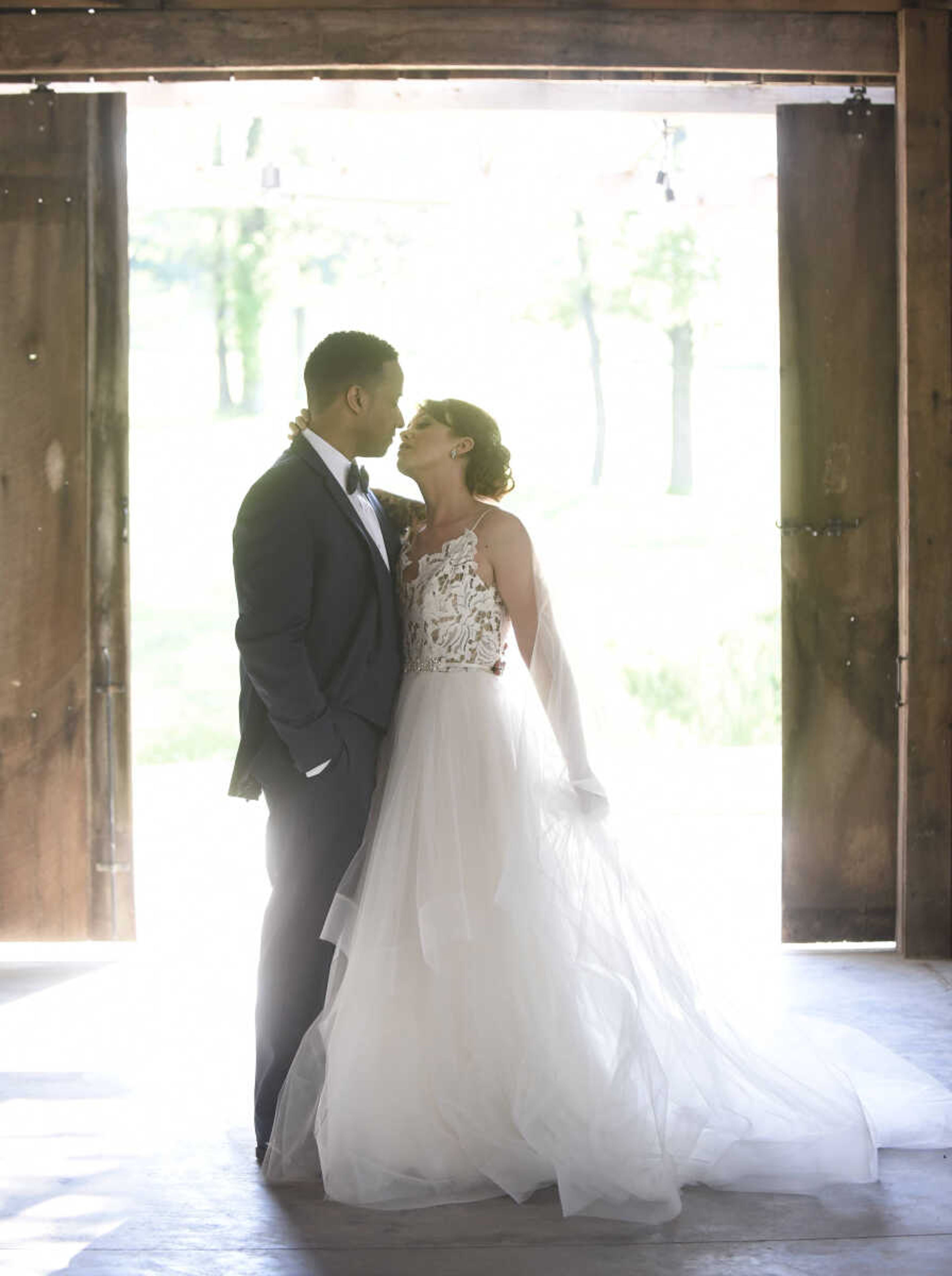 Blush by Hayley Paige: Style 1700 "Halo" 
Ivory lace and tulle bridal ball gown, scalloped V-neck bodice with low open back and strap detail, tiered tulle skirt with horsehair trim. Available at Magnolias Bridal Boutique in Cape Girardeau.

Wedding suits courtesy of Jim's Formal Wear and available at Garber's Men's Wear in Cape Girardeau.