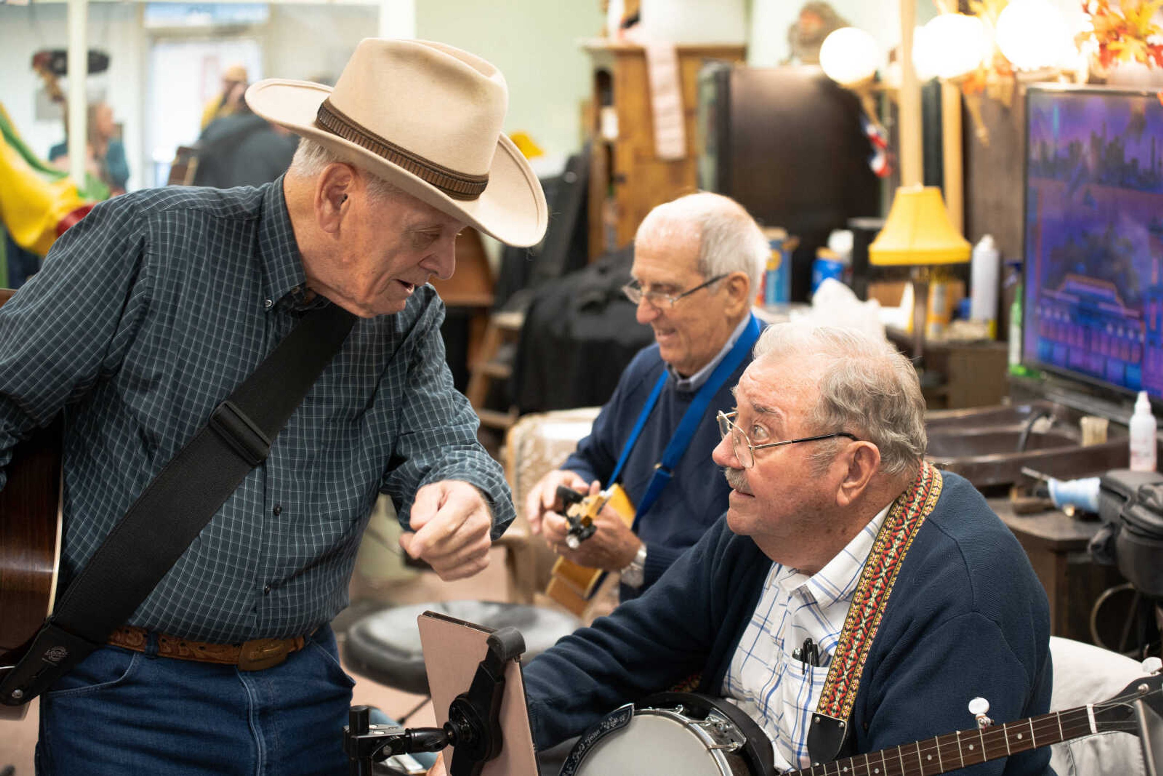 Jim Shandy, left, and Dean Percival talk in between songs as Bo Tollison looks on. Members of the circle come from all over Southeast Missouri to play on Sundays at 4 p.m.