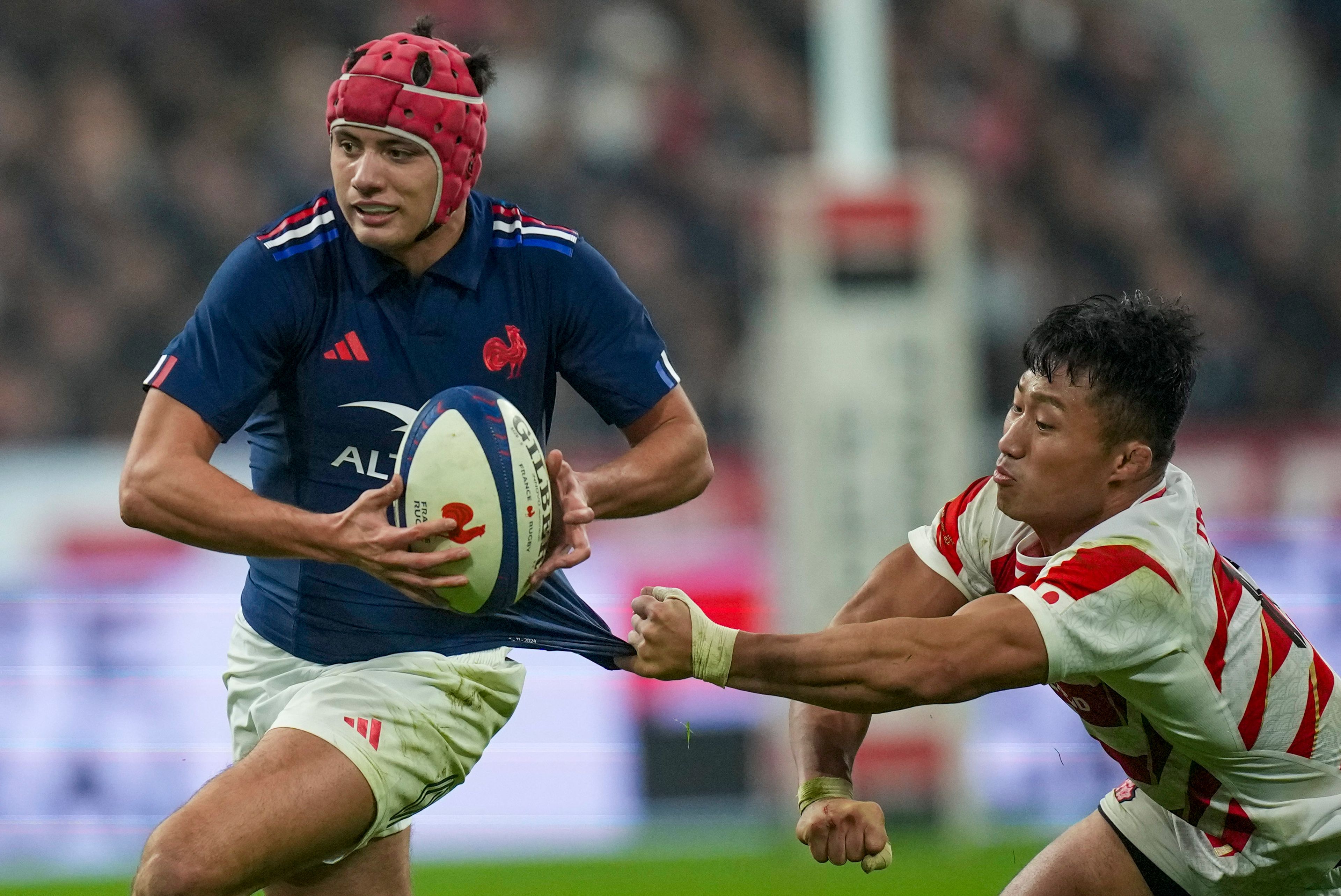 Japan's Tomoki Osada tries to pull back France's Louis Bielle-Biarrey during the Autumn Nations series rugby union match between France and Japan at the Stade de France in Saint-Denis, outside Paris, Saturday, Nov. 9, 2024. (AP Photo/Christophe Ena)