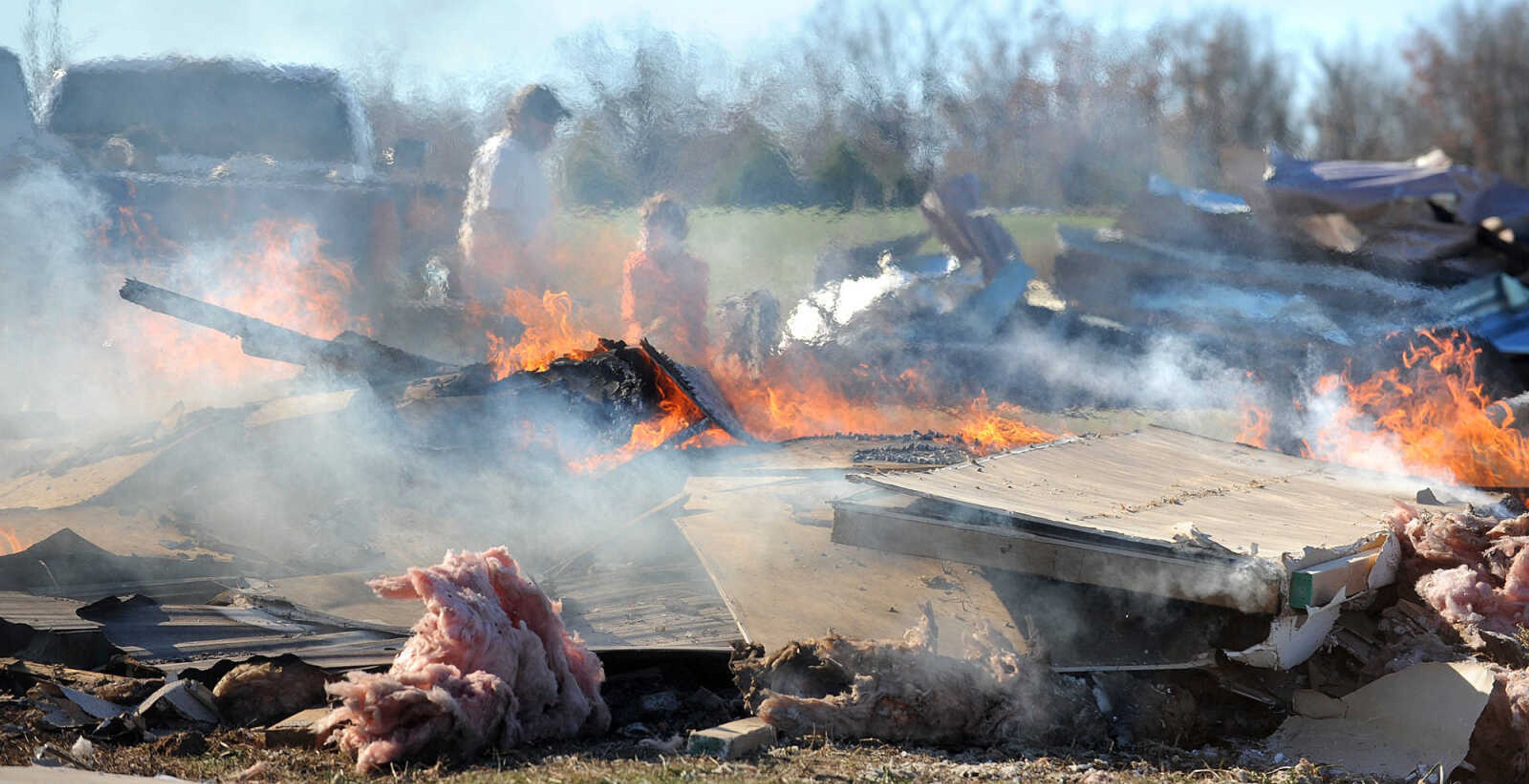 LAURA SIMON ~ lsimon@semissourian.com

Heat and smoke obscure Sharon Daniels, right and her son Thomas, as they burn the the remnants of her mobile home, Monday, Nov. 18, 2013, in Benton, Mo. Sharon Daniels recently purchased the mobile home near her family in a cul-de-sac off of Scott County Road 507. The mobile home moved around 20 feet off it's foundation during the severe weather that tore through the region on Sunday.