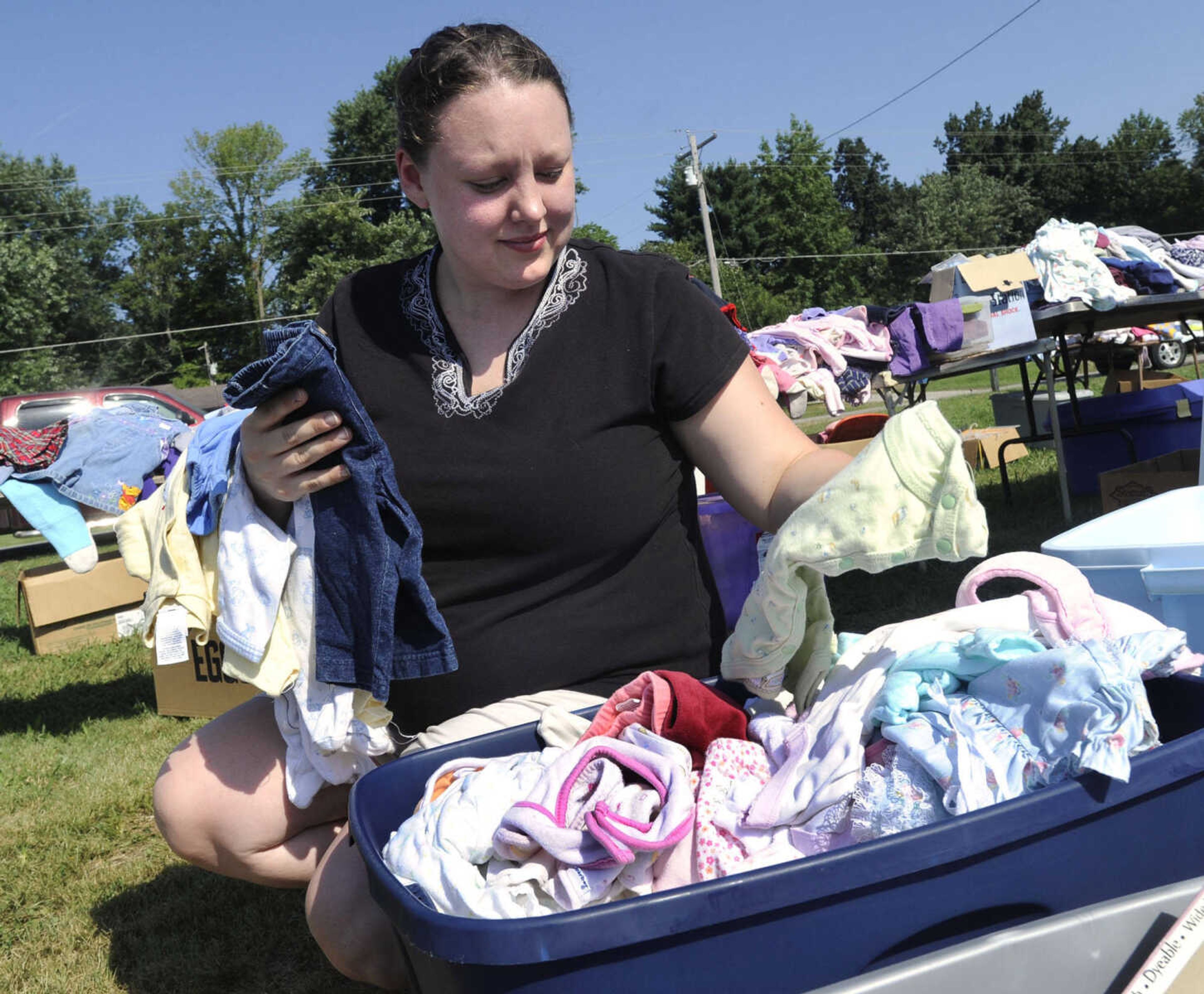 Brandi Heise of Scott City checks out an assortment of baby clothes during the Highway 61 Yard Sale Saturday, Aug. 31, 2013 in Jackson.