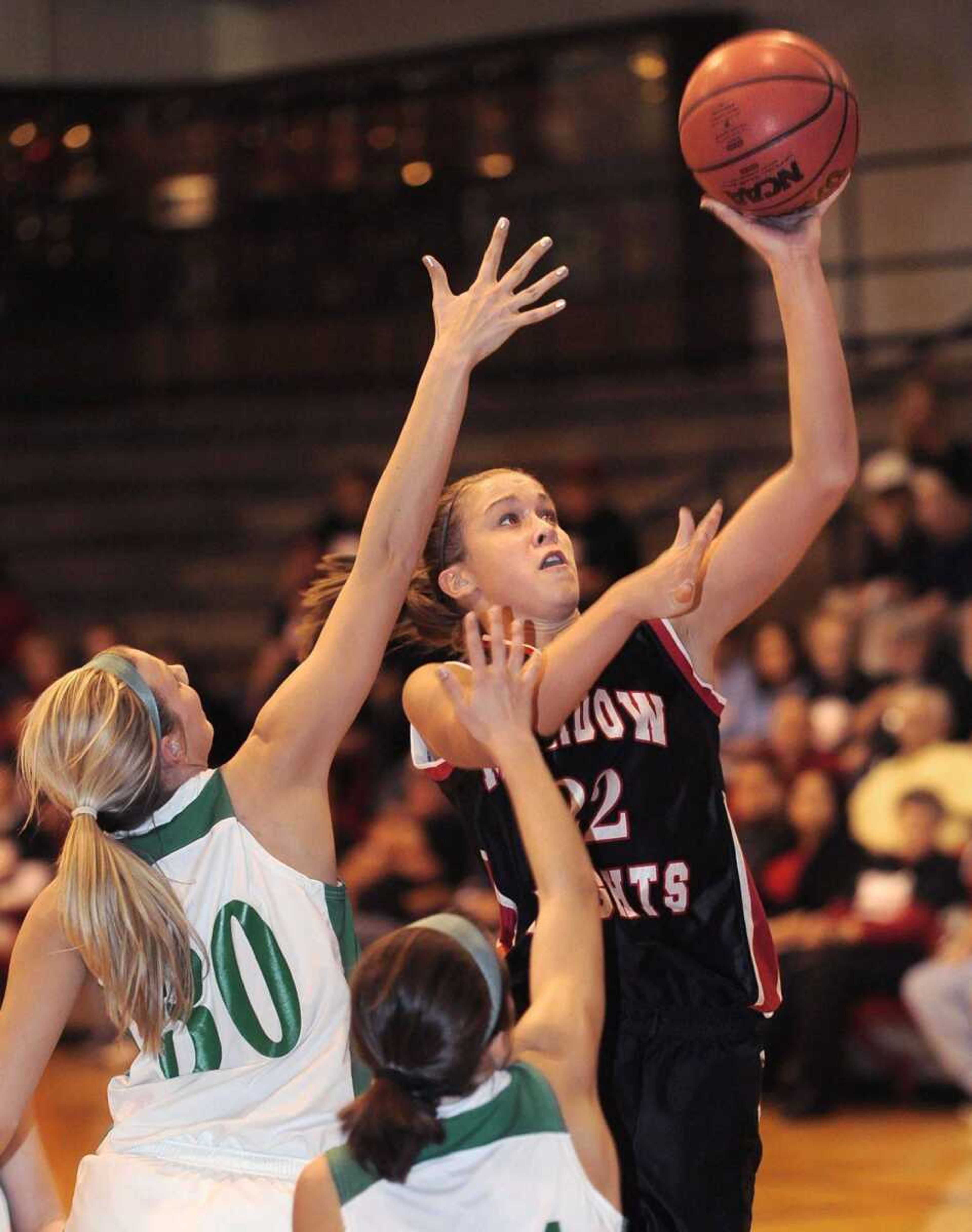 Meadow Heights senior Erin Bollmann takes a shot against New Haven's Kayla Oetterer, left, and Kierstin Monzyk during the first quarter of their Class 2 sectional game Wednesday in Park Hills, Mo. (Fred Lynch)