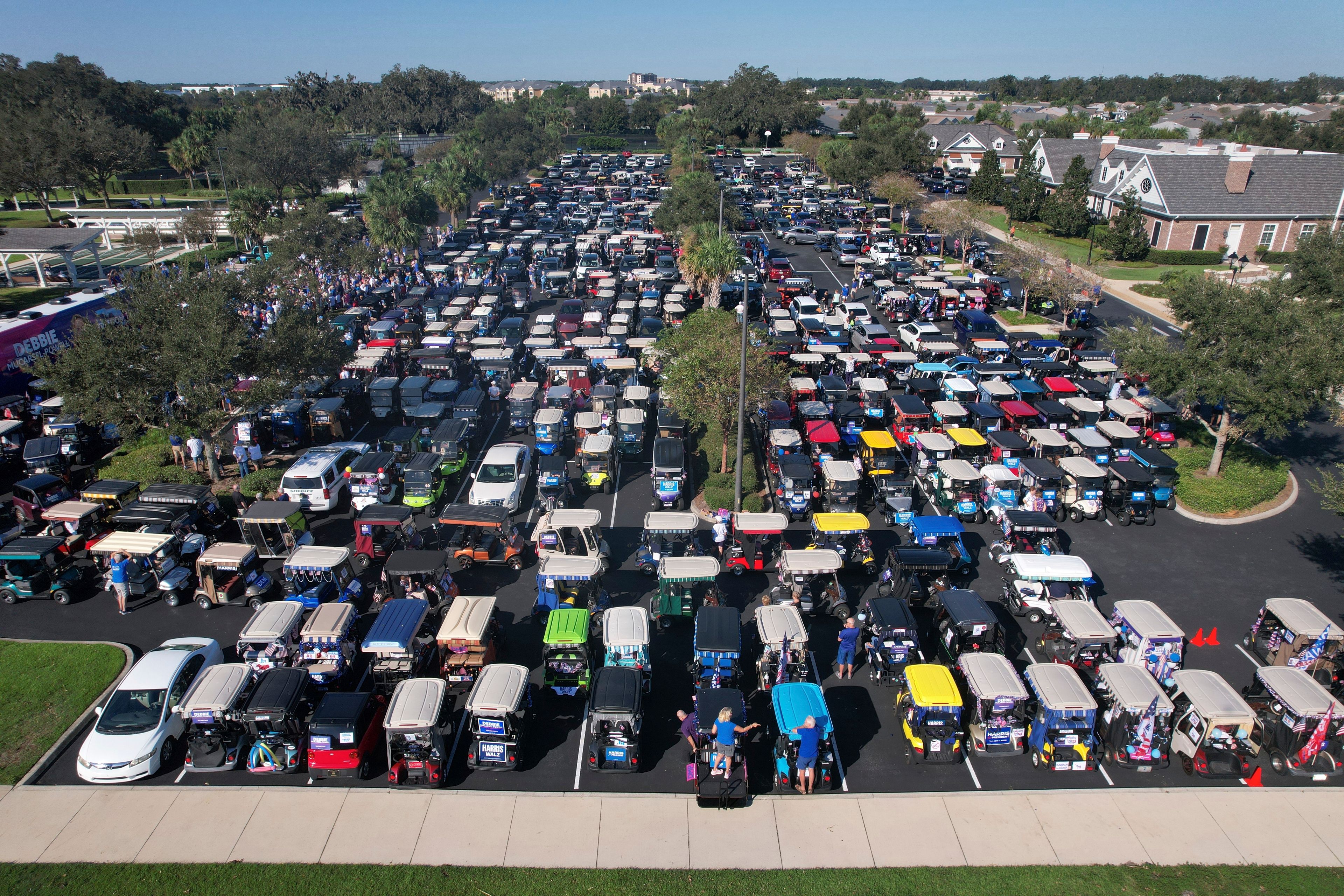 Hundreds of supporters of Democratic presidential nominee Vice President Kamala Harris prepare to participate in a golf cart parade to deliver their completed mail-in ballots, in The Villages, Fla., Monday, Oct. 14, 2024. The Villages, one of the world's largest retirement communities, has long been known as a conservative stronghold, but Democrats energized by Harris' candidacy have quietly become more visible. (AP Photo/Rebecca Blackwell)