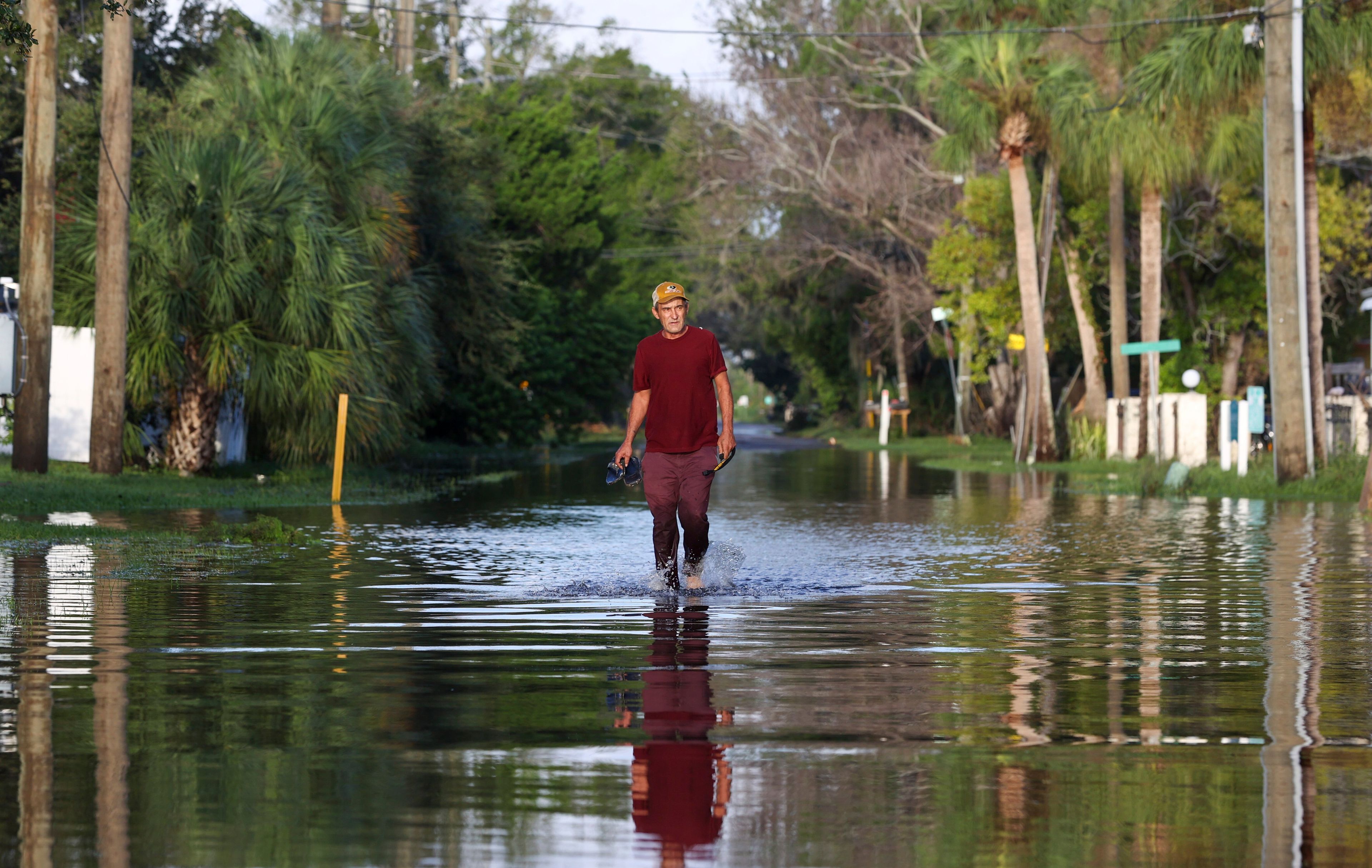 James Wilder, 55, of New Port Richey, Fla., walks along a flooded street from Hurricane Helene at Green Key Road near US 19 Friday, Sept. 27, 2024 in New Port Richey. (Chris Urso/Tampa Bay Times via AP)