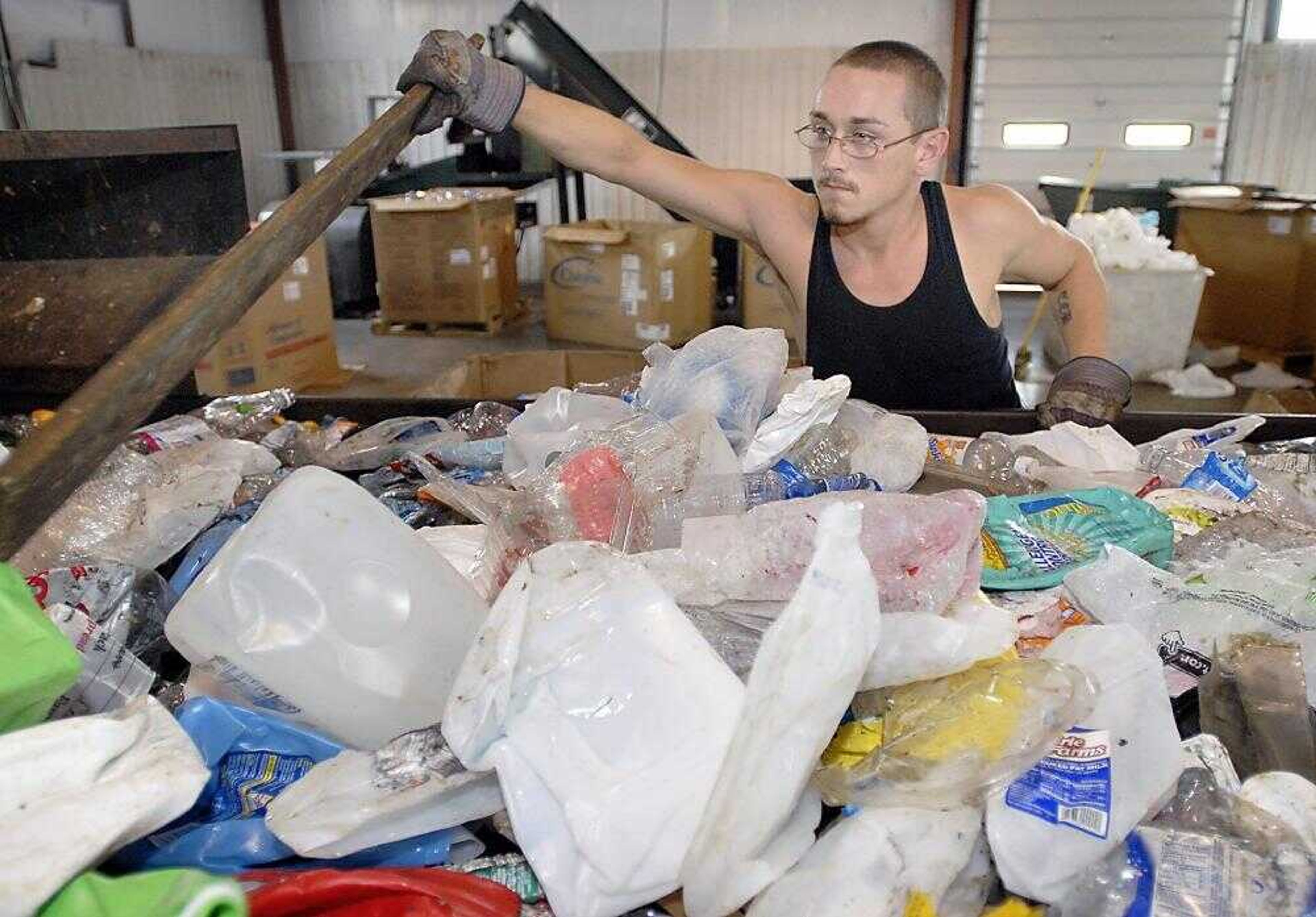 Cape Girardeau City Jail inmate Tyler Borgfield moved plastics along a conveyer belt to be sorted Friday at the Cape Gir-ardeau Recycling Center. Inmates earn five dollars per hour toward their fines. (Kit Doyle)