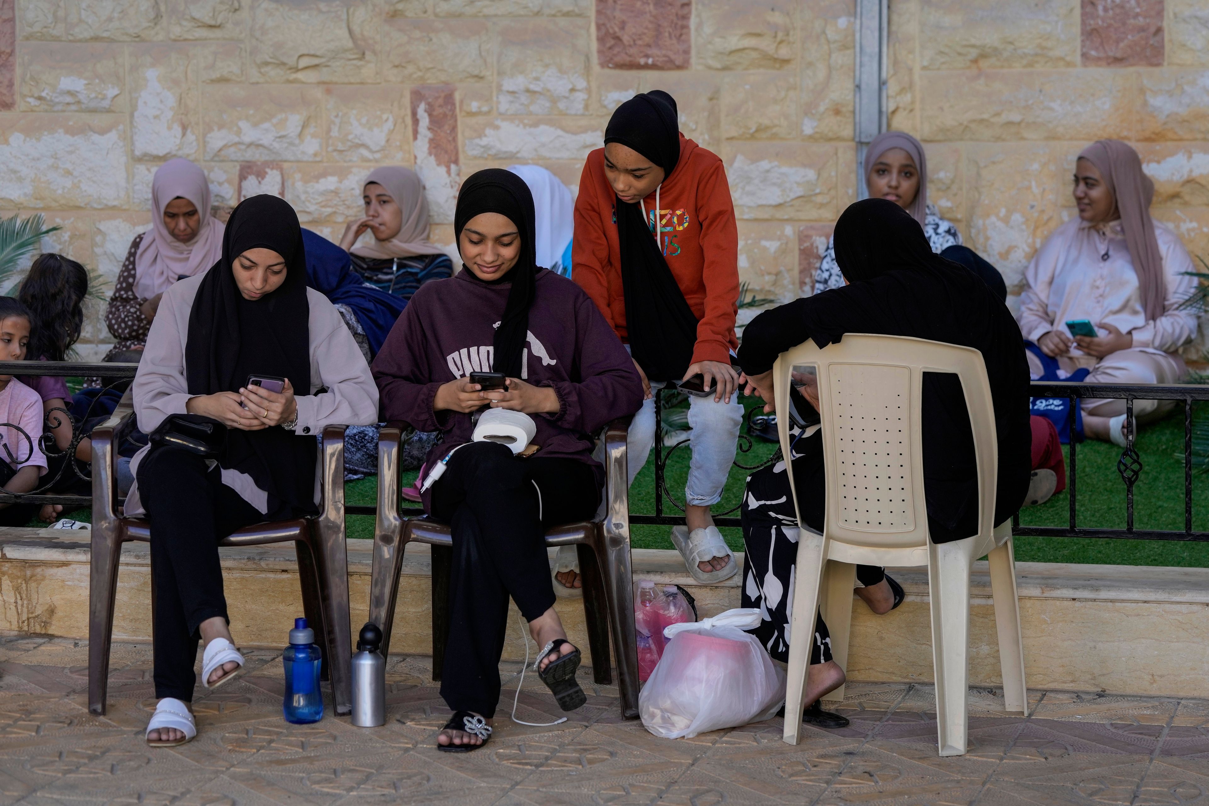 Displaced people sit at a vocational training center run by the U.N. agency for Palestinian refugees, or UNRWA, in the southern town of Sebline, south of Beirut, Lebanon, Friday, Oct. 4, 2024, after fleeing the Israeli airstrikes in the south. (AP Photo/Bilal Hussein)