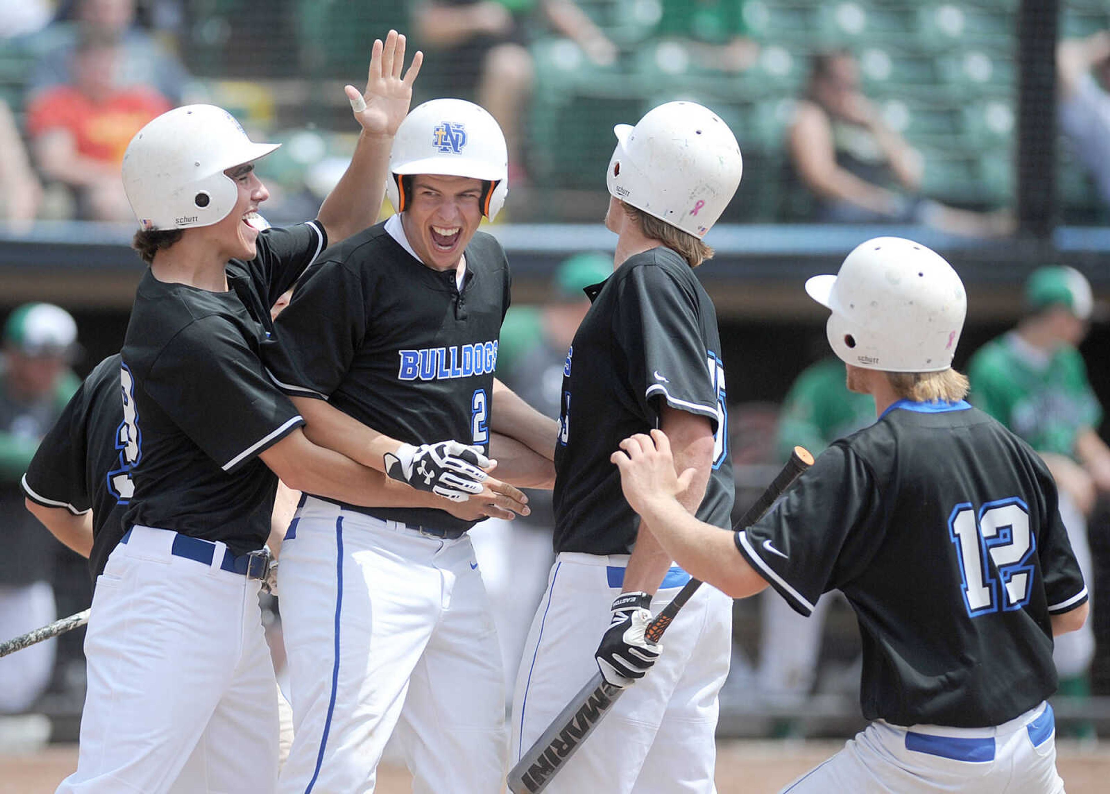 Notre Dame players congratulate Chase Urhahn on hitting a two-run RBI in the the top of the fourth inning of the Bulldogs Class 4 semifinal against Smithville, Friday, June 5, 2015, in O'Fallon, Missouri. Urhahn scored on an error. Notre Dame won 13-3 in six innings. (Laura Simon)