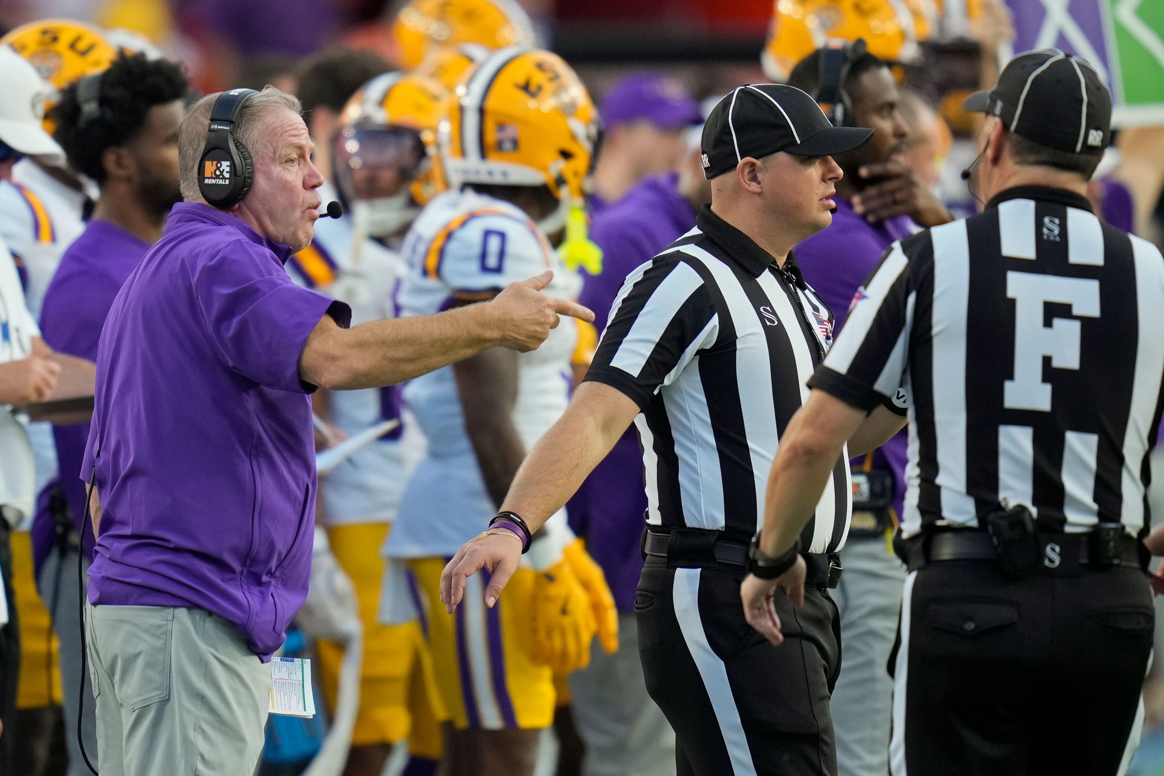 LSU head coach Brian Kelly, left, makes a point with officials during the first half of an NCAA college football game against Florida, Saturday, Nov. 16, 2024, in Gainesville, Fla. (AP Photo/John Raoux)