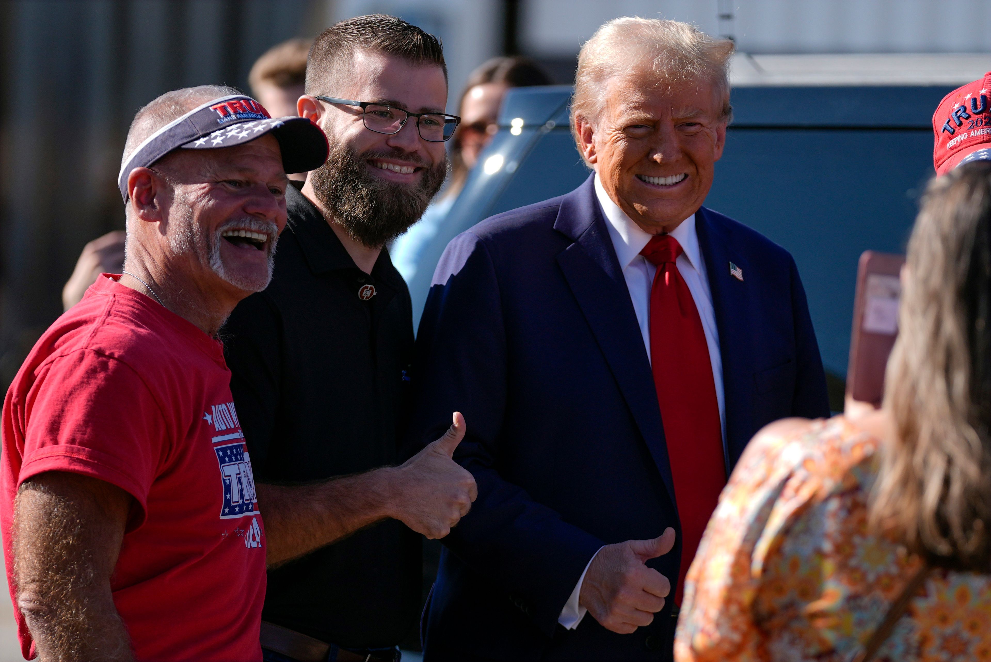 Republican presidential nominee former President Donald Trump poses for a photo as he arrives at Detroit Metropolitan Wayne County Airport, Friday, Oct. 18, 2024, in Detroit. (AP Photo/Evan Vucci)