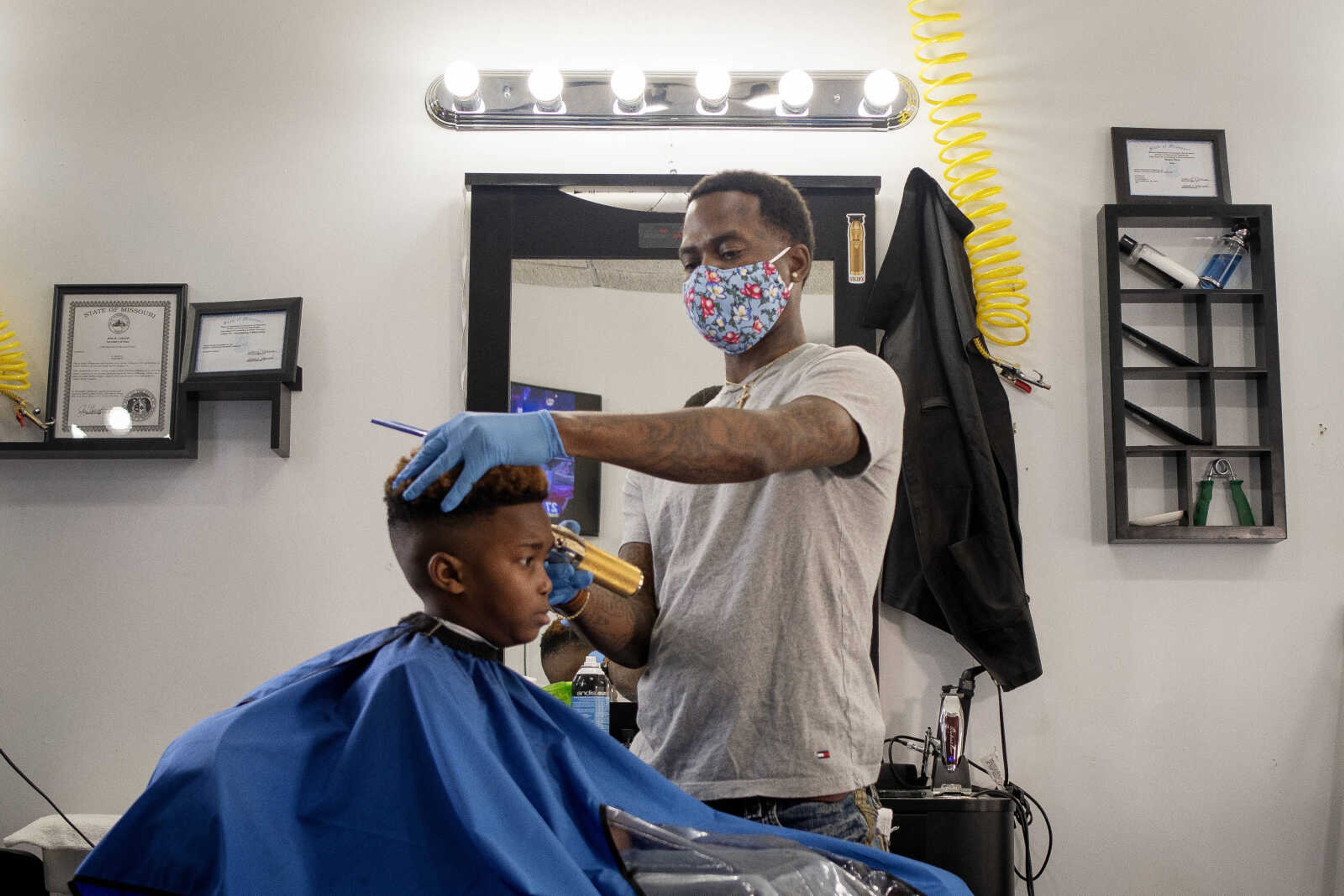 Cosmologist Antonio Johnson, owner of A+ Kutz, wears a face mask while cutting the hair of Omiere Johnson, 6, of Cape Girardeau, on Tuesday, March 17, 2020, at the shop in Cape Girardeau. Antonio, originally from Sikeston, Missouri, and now Cape Girardeau, said he usually always wears gloves while cutting hair, but has been wearing the face mask since the end of last week due to concerns about coronavirus. "I'm trying to keep myself safe," Antonio said.