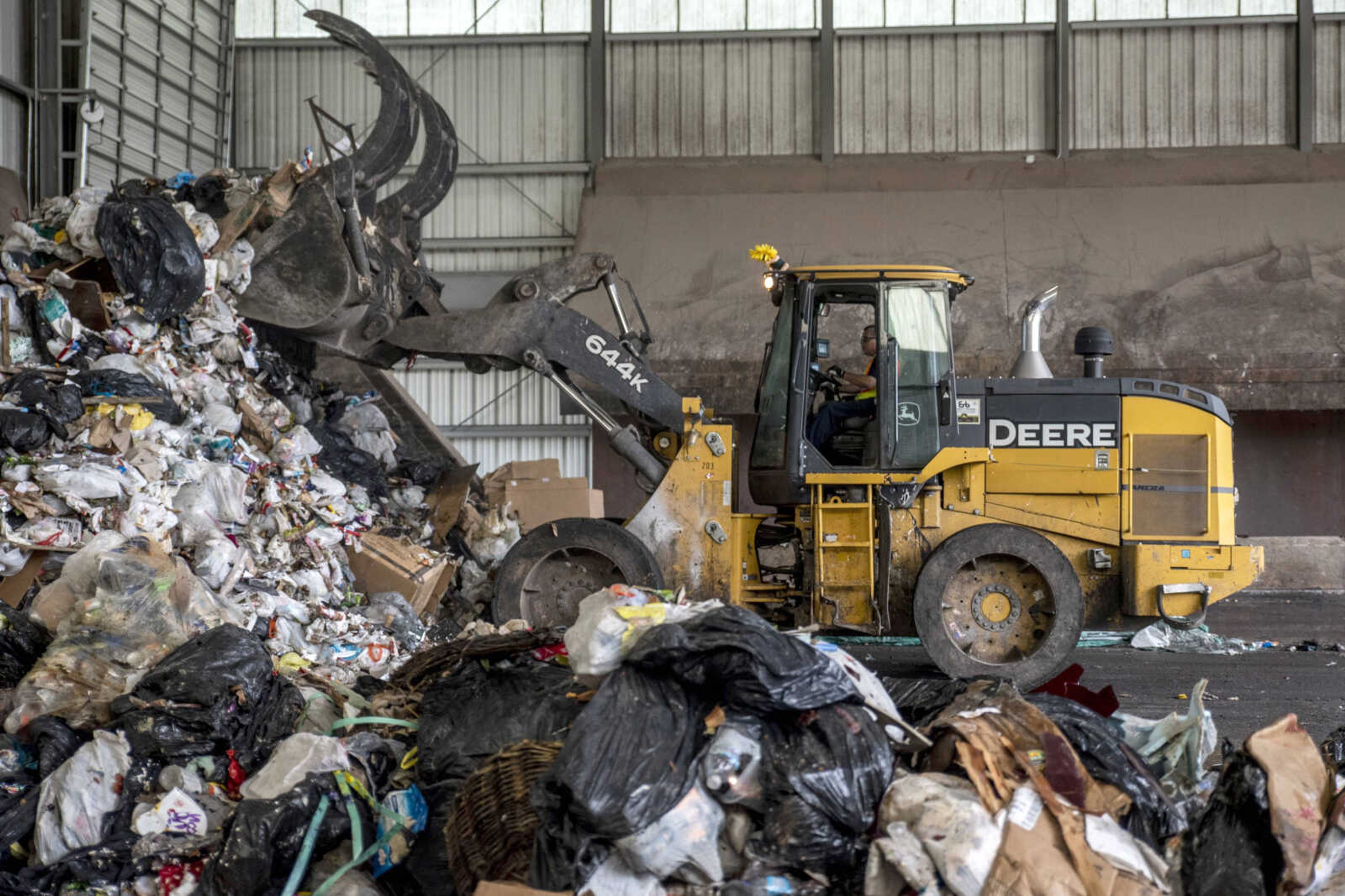 A city employee shoves dumped-off trash into piles Monday at the Cape Girardeau Public Works Transfer Station in Cape Girardeau.