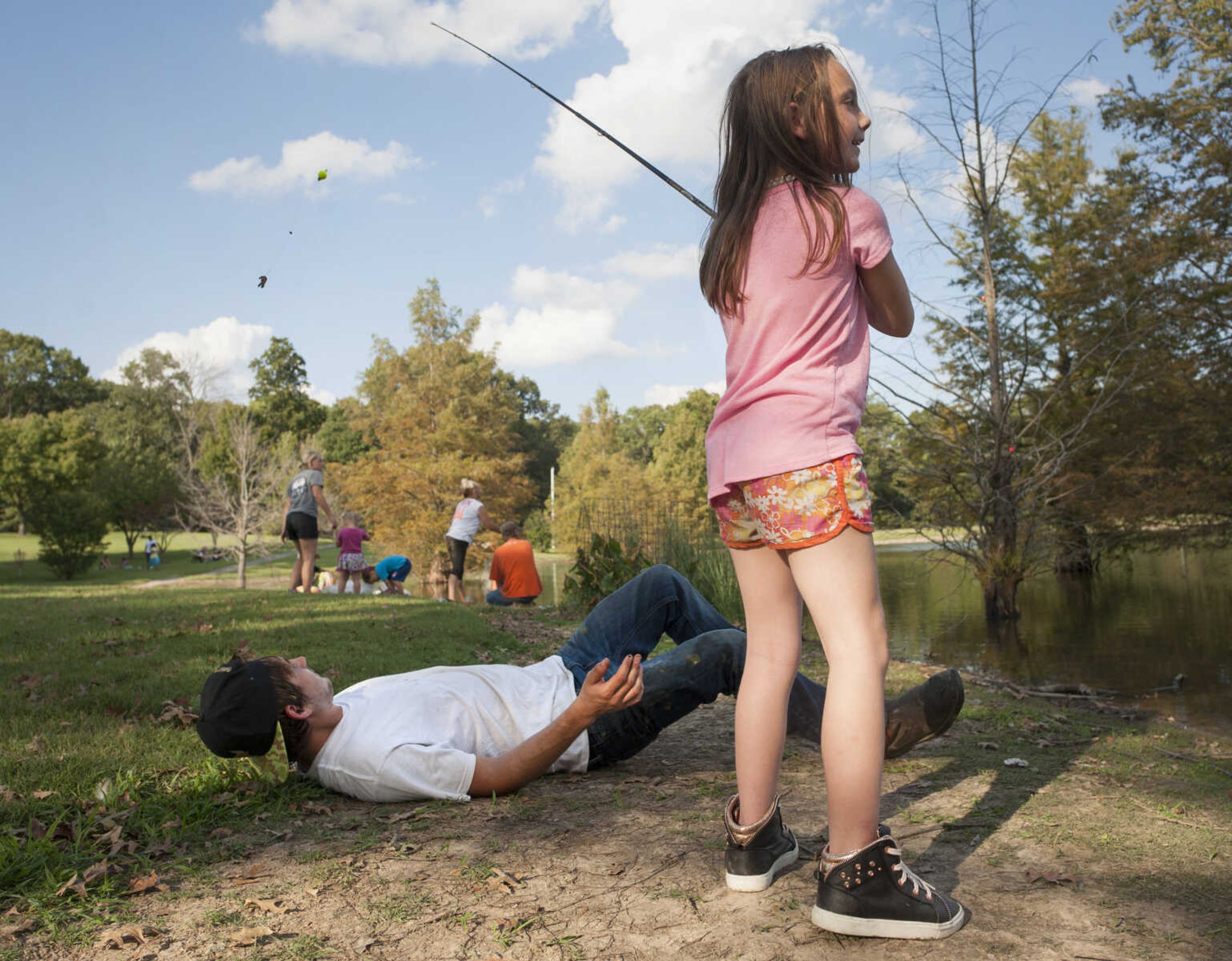 Damien Helton drops to the ground to avoid being hooked as his 7-year-old sister Katelyn Brice casts a line Sept. 29, 2019, at Cape County Park North.