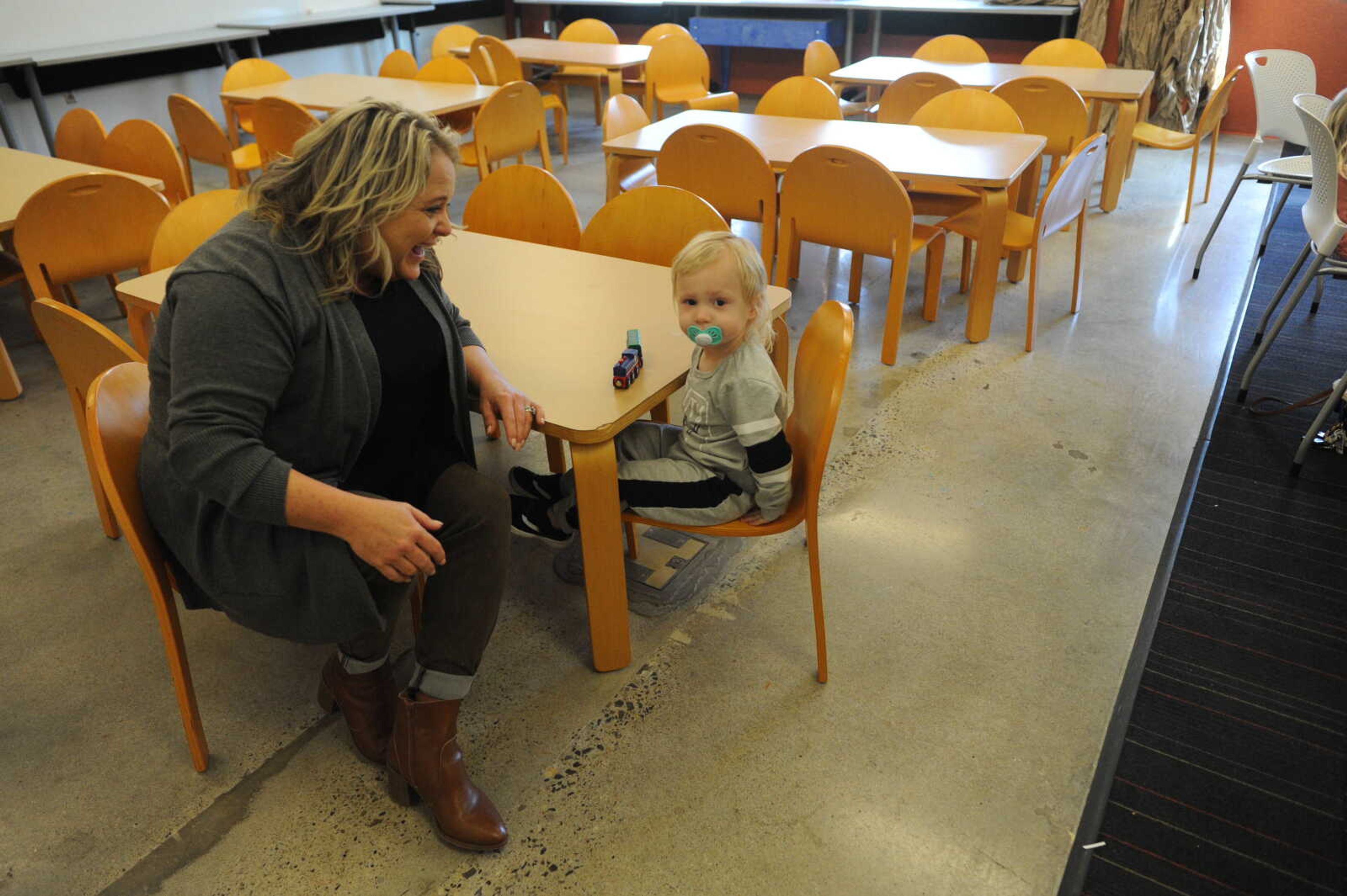 Rowan Ulrich and his grandmother, Michelle Quade take a break from story time to play with their toy train.