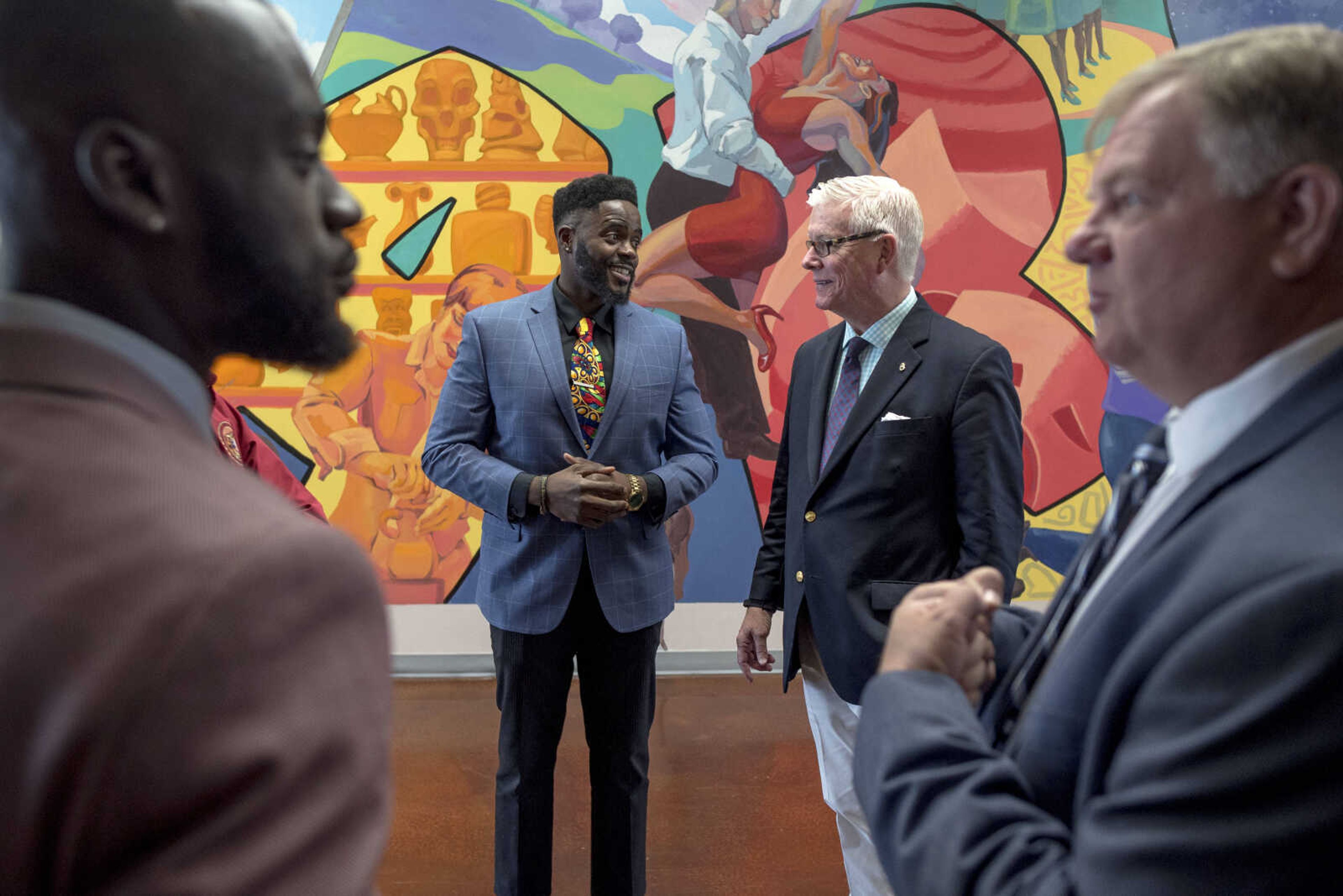 Honorable Young Men Club co-founders Wyky Jean, center left, and Kweku Arkorful, far left, socialize with former Missouri Lt. Gov. Peter Kinder, center right, and Representative Barry Hovis, far right, during a visit from regional politicians and members of the Missouri state legislature's black caucus Friday, Oct. 25, 2019, at Cape Central High School.