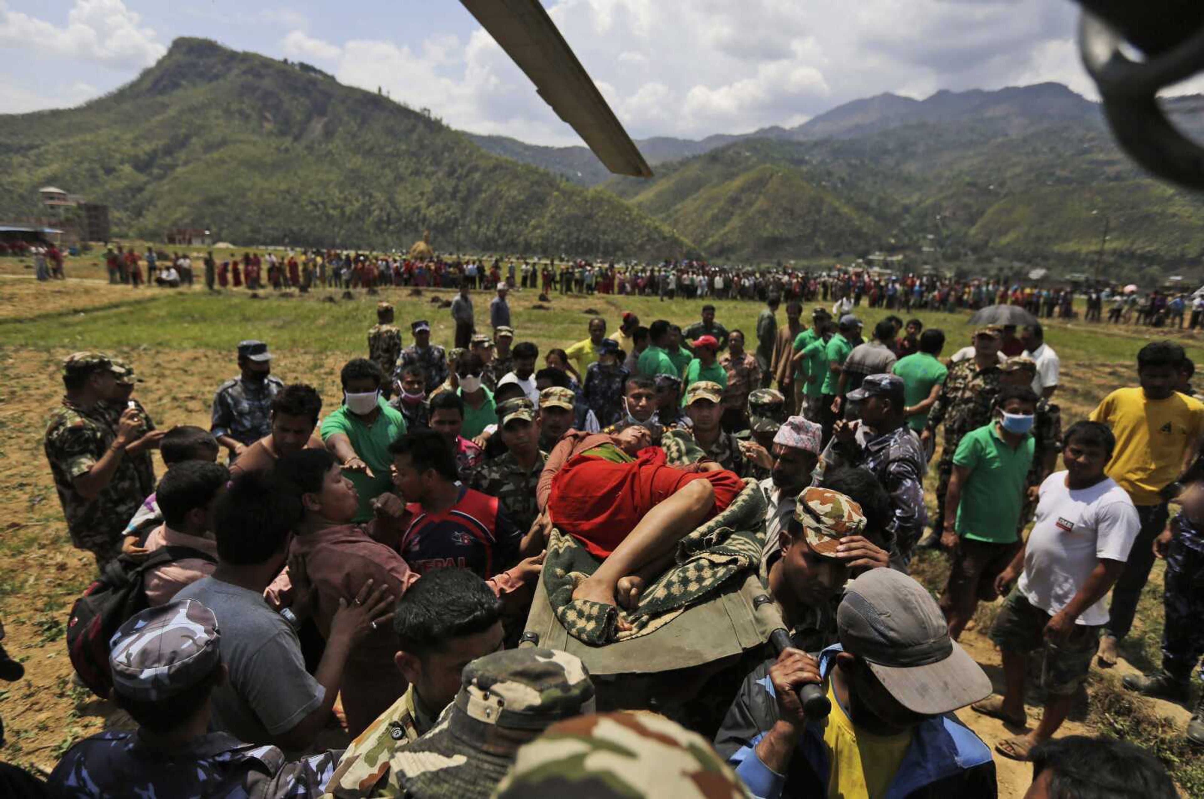 Nepalese soldiers carry a wounded woman to a waiting Indian air force helicopter Monday as they evacuate victims of the earthquake from Trishuli Bazar to Kathmandu airport in Nepal. More images from Nepal may be seen in a gallery at semissourian.com. (Altaf Qadri ~ Associated Press)