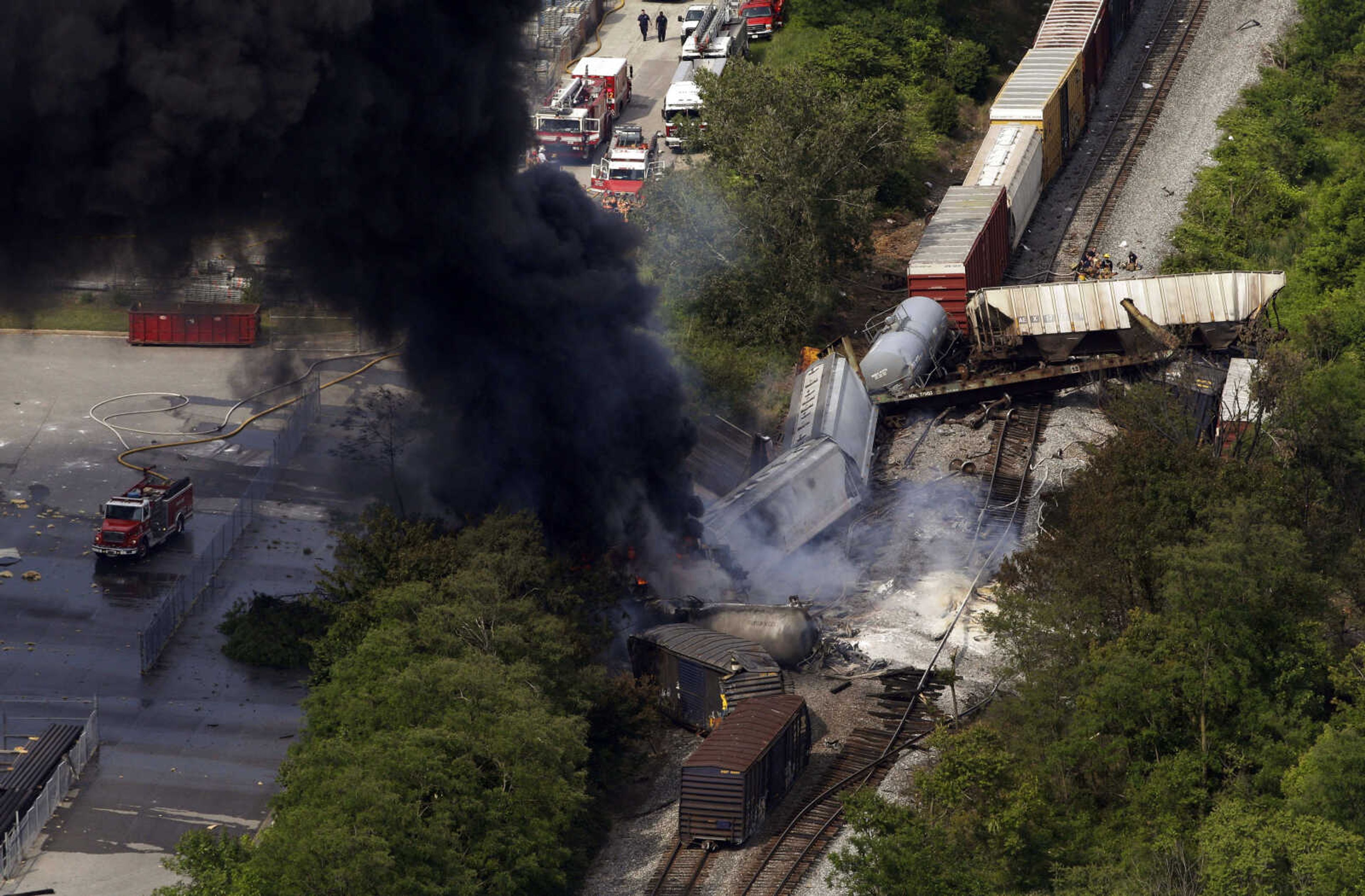 FILE- In this Tuesday, May 28, 2013, file photo, a fire burns at the site of a CSX freight train derailment, in Rosedale, Md., where fire officials say the train crashed into a trash truck, causing an explosion that rattled homes at least a half-mile away and collapsed nearby buildings, setting them on fire. The nation's railroads are safer than ever, despite recent high-profile accidents like this week's fiery derailment in Maryland. Derailments and crossing accidents have steadily declined nationwide even as businesses have come to increasingly rely on trains to move their raw materials and products. (AP Photo/Patrick Semansky)