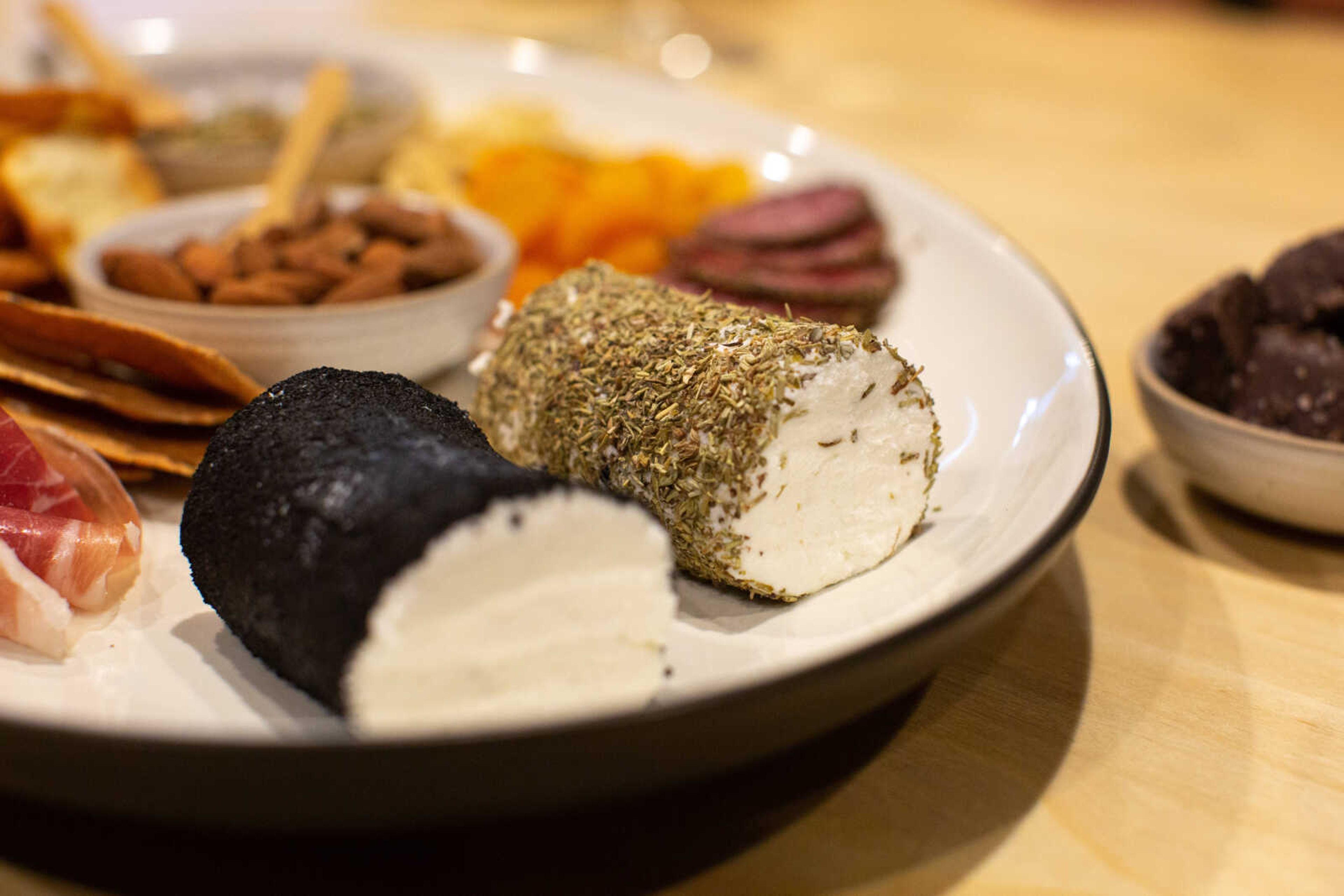 An ash-coated log of chèvre sits next to a log coated in herbs de Provence. Trever and Steffie Duncan often share the cheese they make at dinner parties with friends.